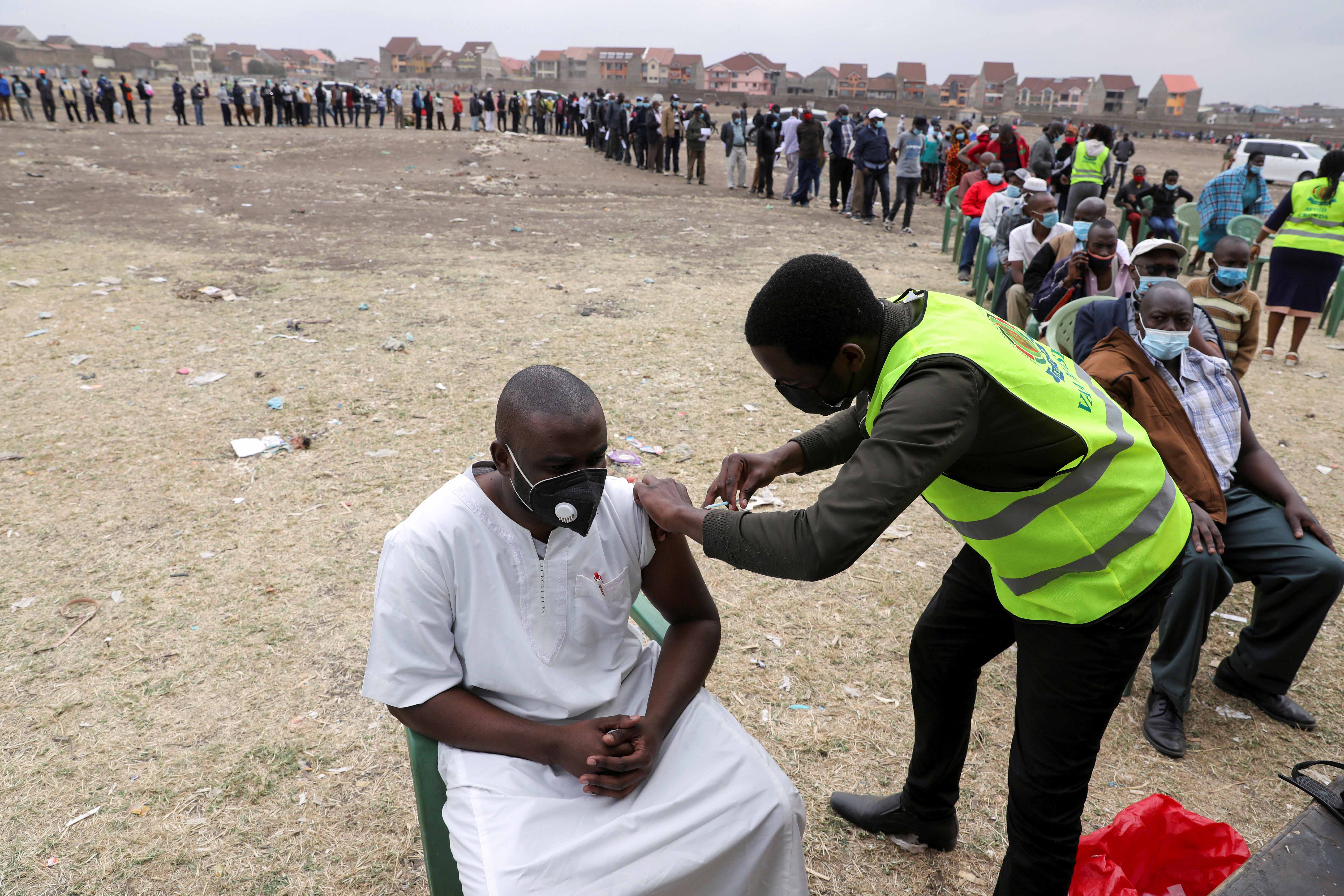 A health worker administers an AstraZeneca COVID-19 vaccine, donated to Kenya by the UK government, to a man in Nairobi on August 8, 2021 [Reuters/Baz Ratner]
