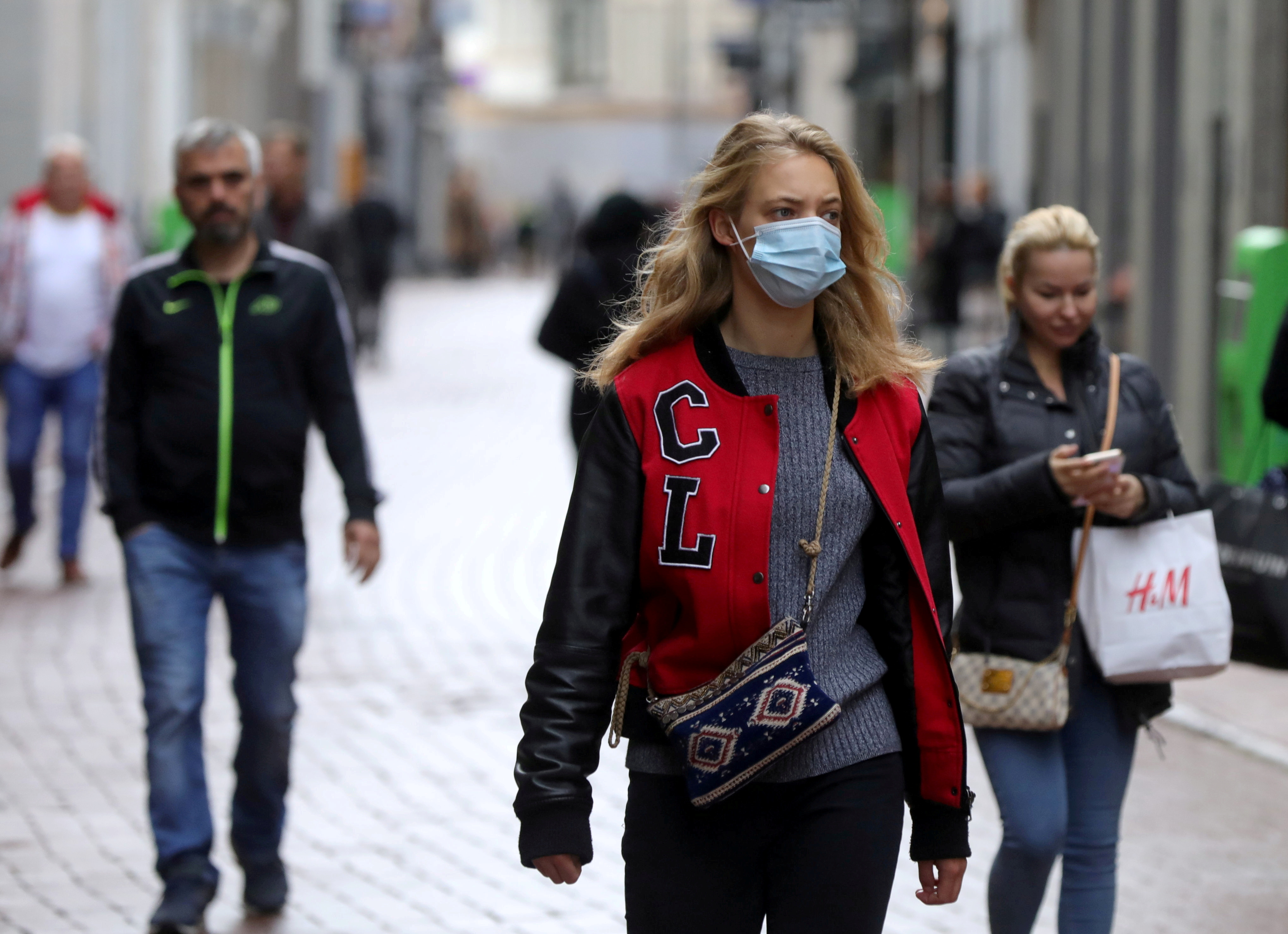 People with and without protective masks walk in the Netherlands
