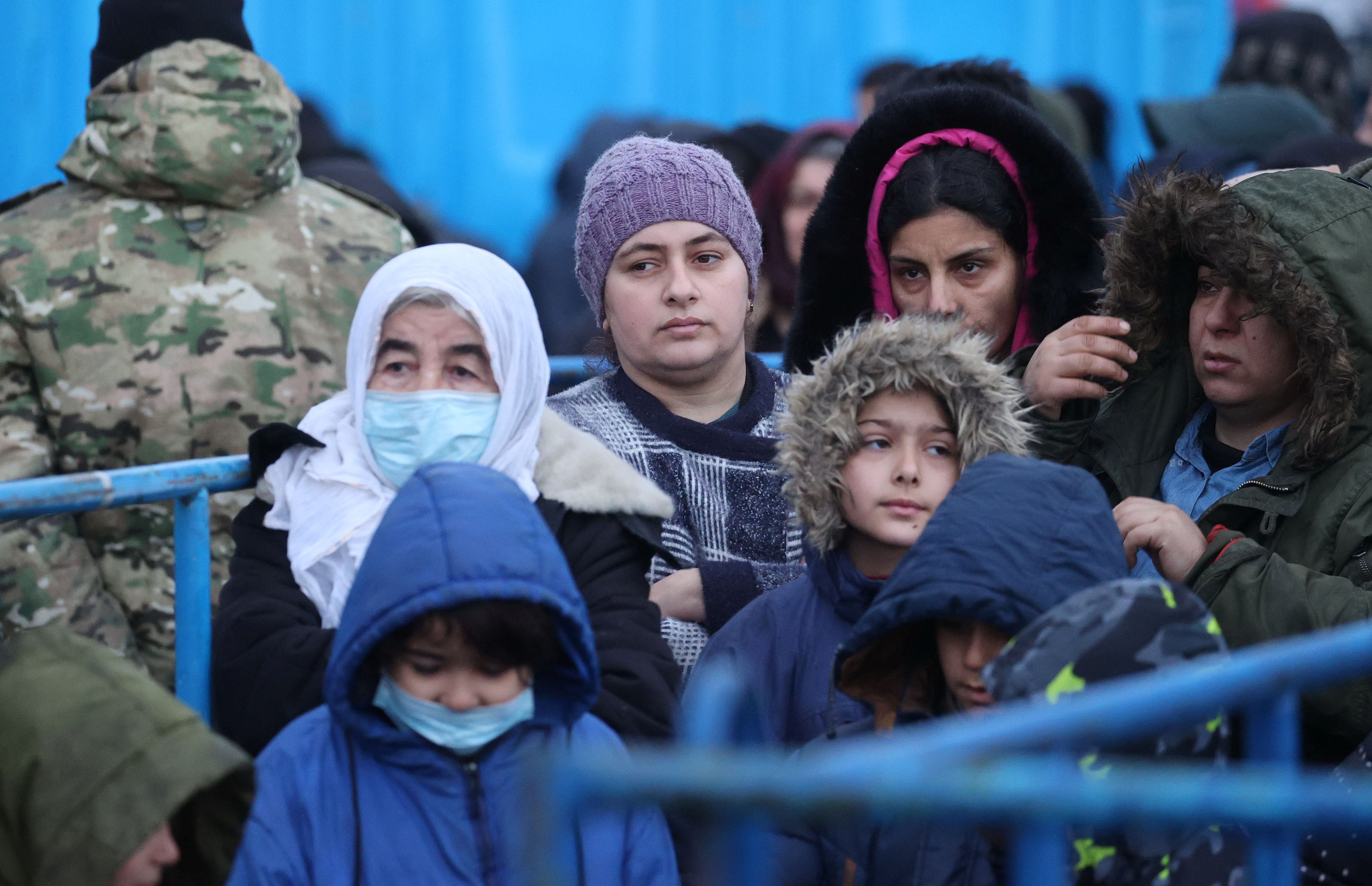 People gather during the distribution of humanitarian aid among refugees near the transport and logistics centre Bruzgi on the Belarusian-Polish border in the Grodno region, Belarus November 21 [Maxim Guchek/BelTA/Handout via Reuters]