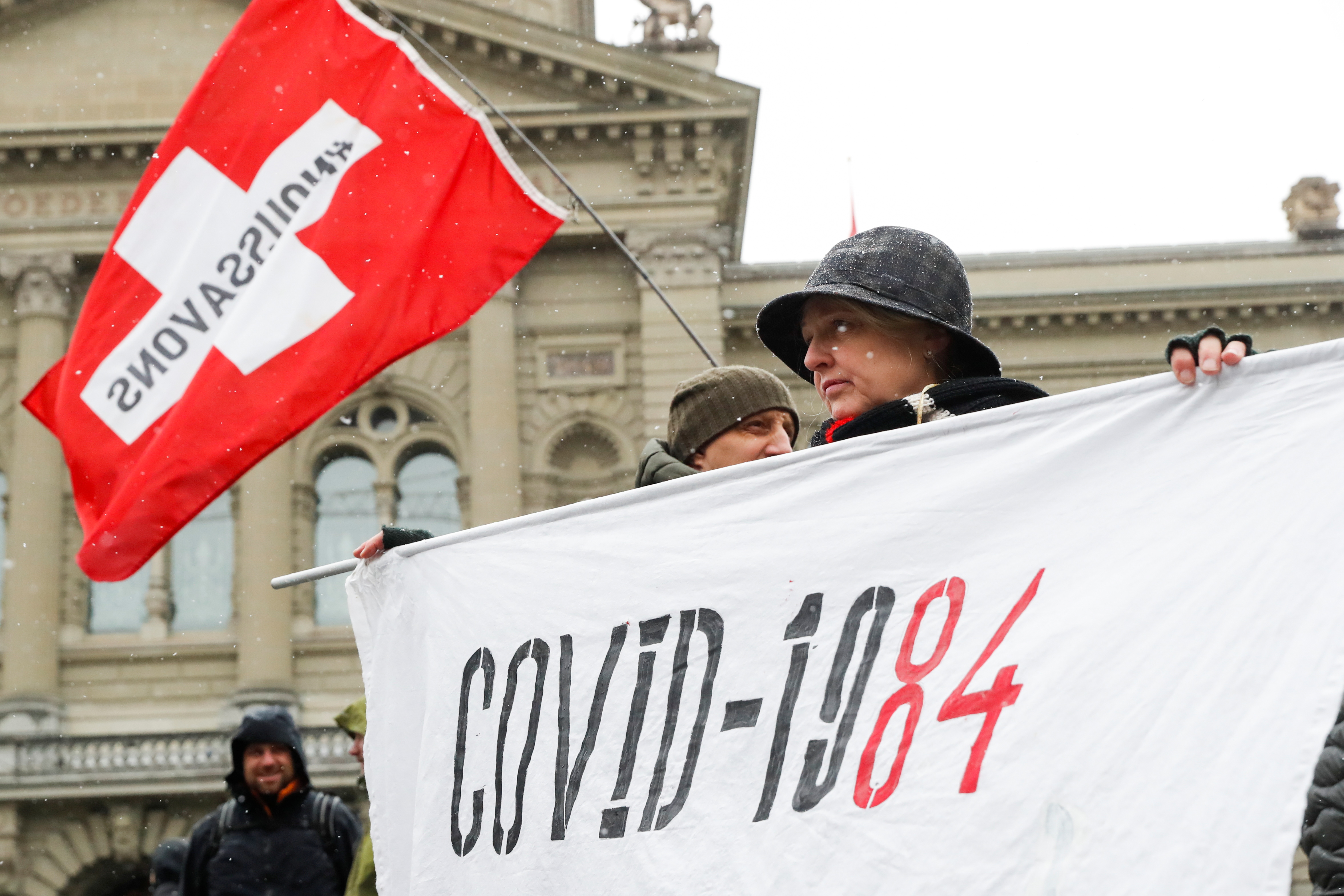A woman holds a banner during a protest against a coronavirus disease (COVID-19) law 