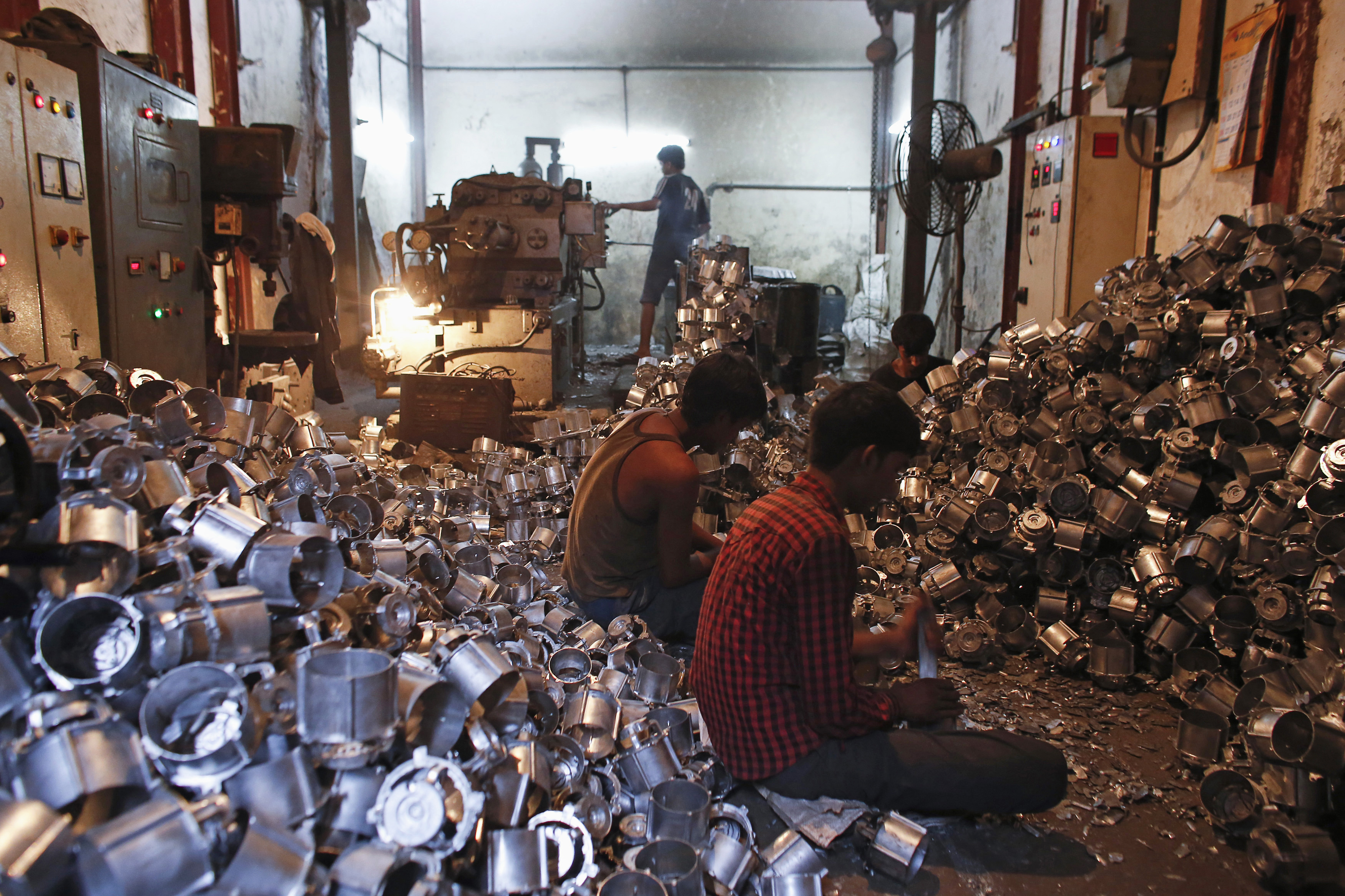 Workers make parts for household mixers at a workshop in Mumbai, India