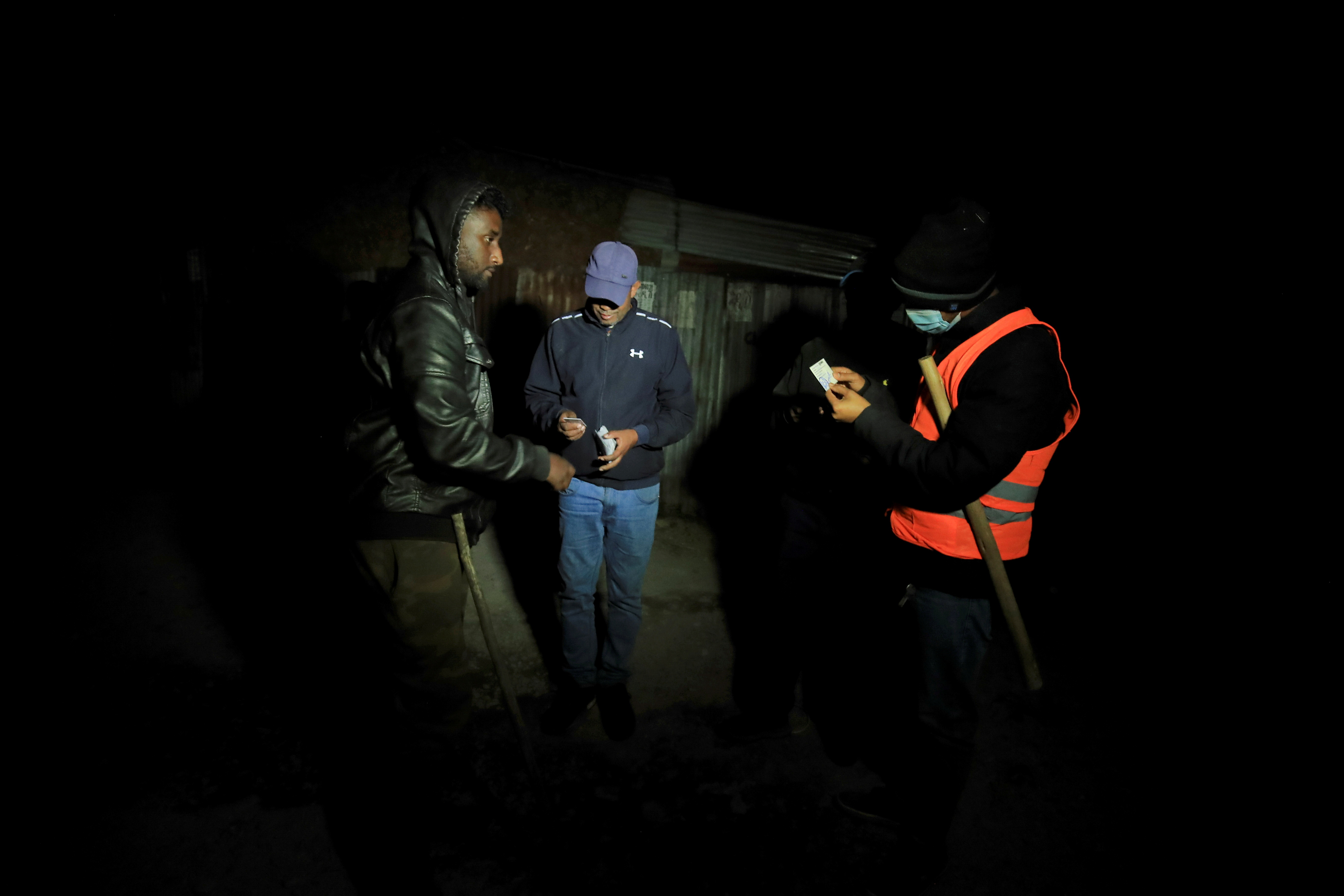 Unarmed vigilantes review identification cards of citizens in Bole, following the Ethiopian Prime Minister Abiy Ahmed's call for citizens to protect their areas from Tigray People's Liberation Front (TPLF), in Addis Ababa, Ethiopia, November 19, 2021. Picture taken November 19, 2021.