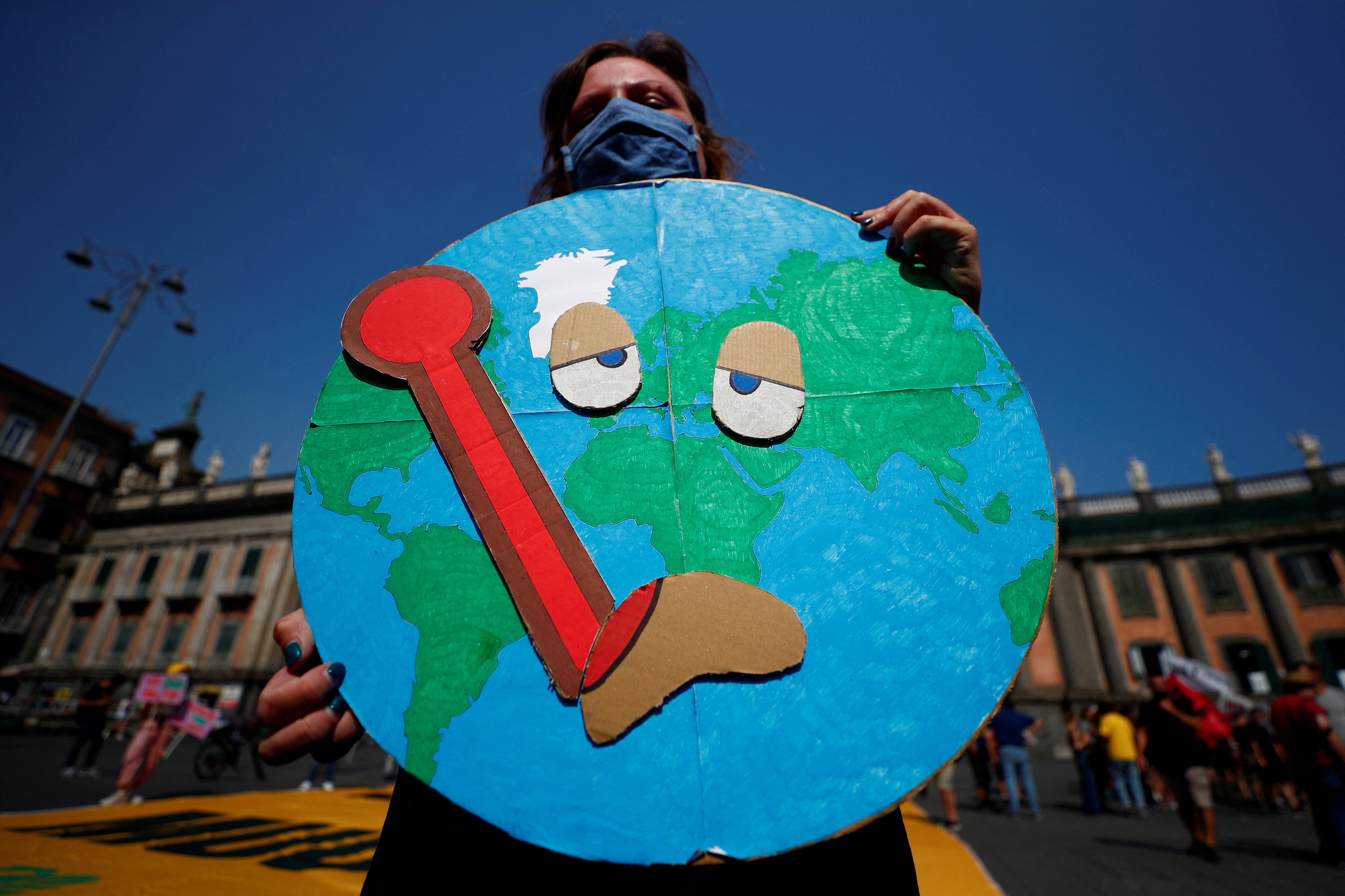 A protester holds a placard during a demonstration demanding more action while G20 climate and environment ministers hold a meeting in Naples, Italy on July 22, 2021