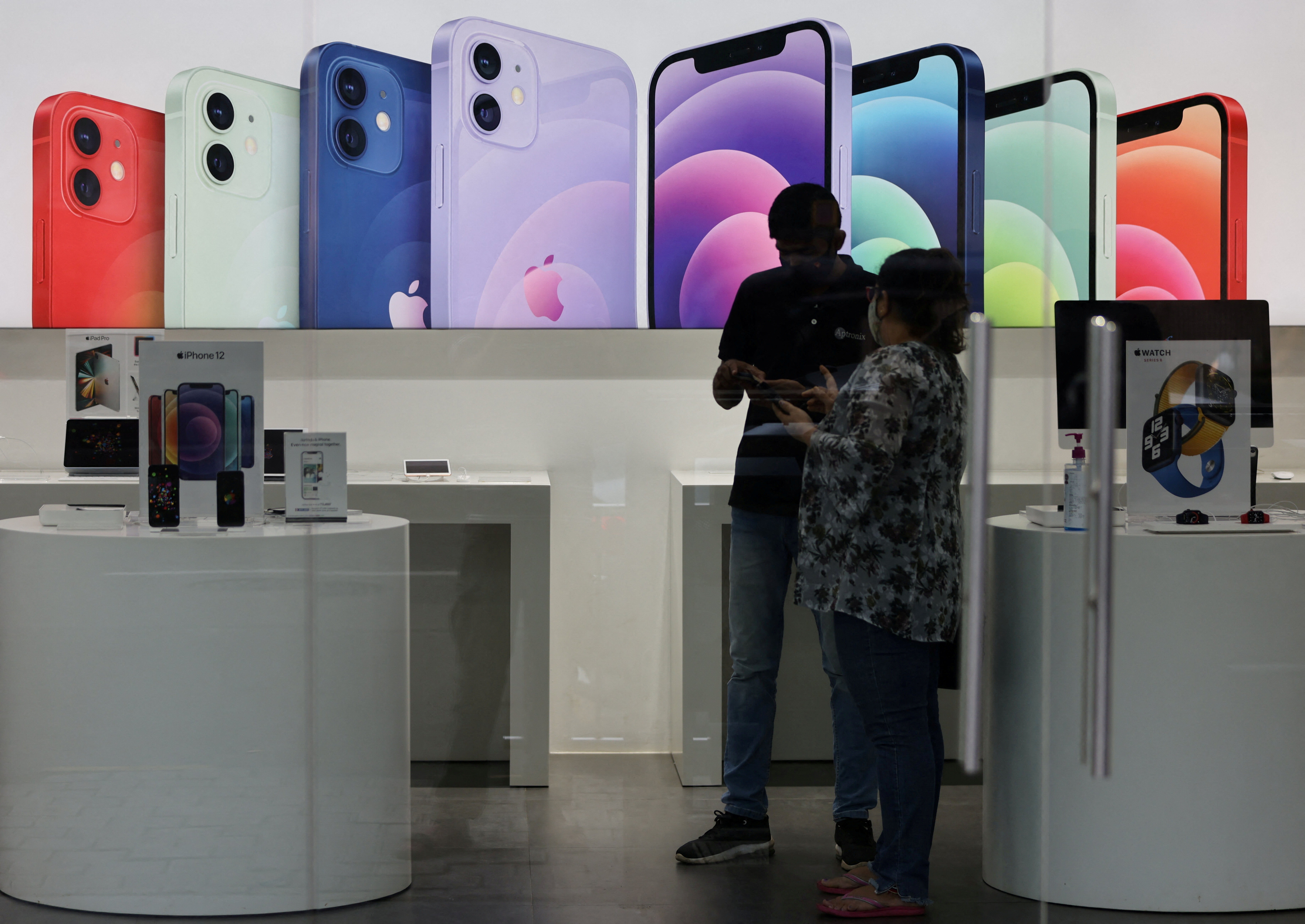 A salesperson speaks to a customer at an Apple reseller store in Mumbai, India