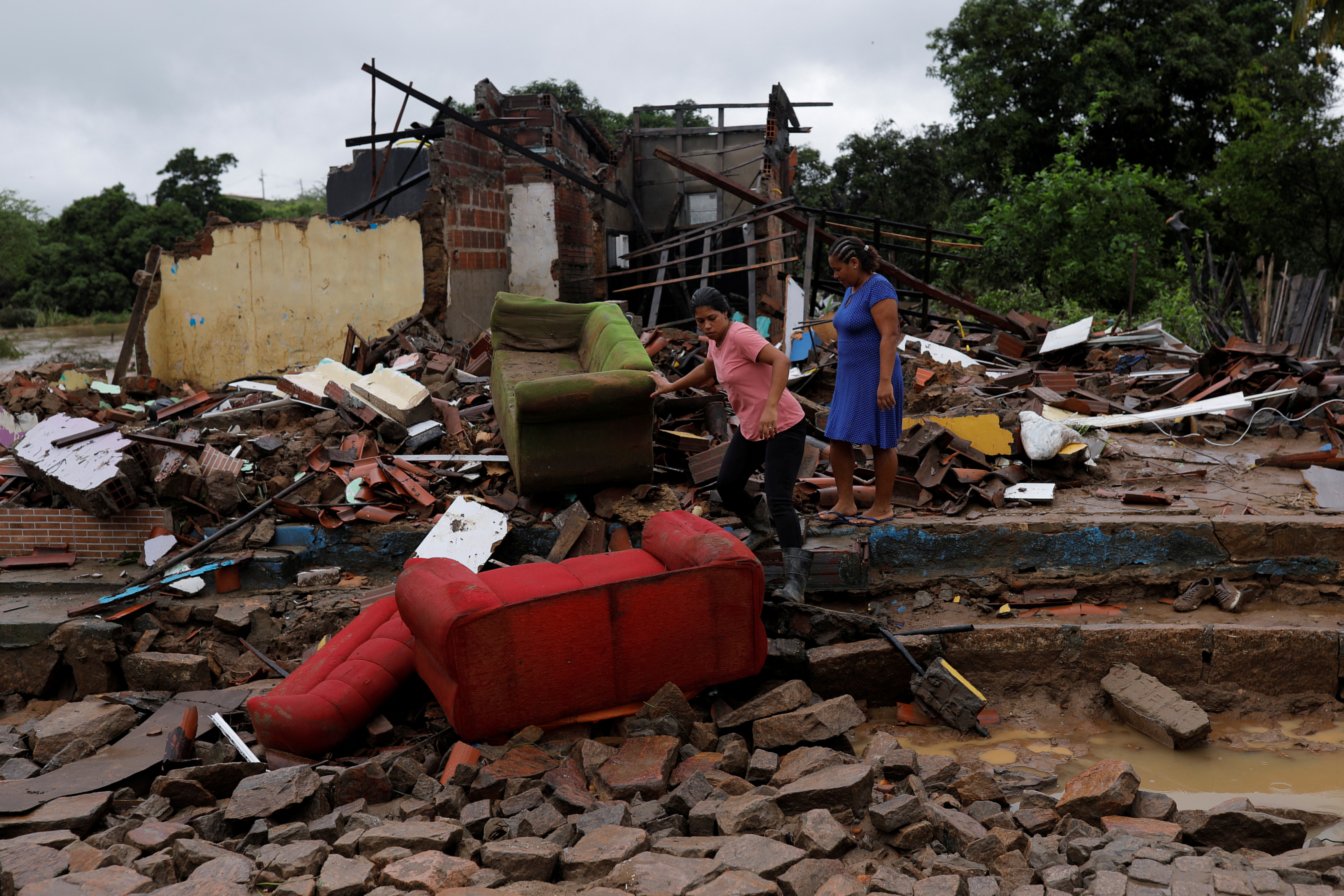 Residents clean out their flooded homes in Bahia state, Brazil
