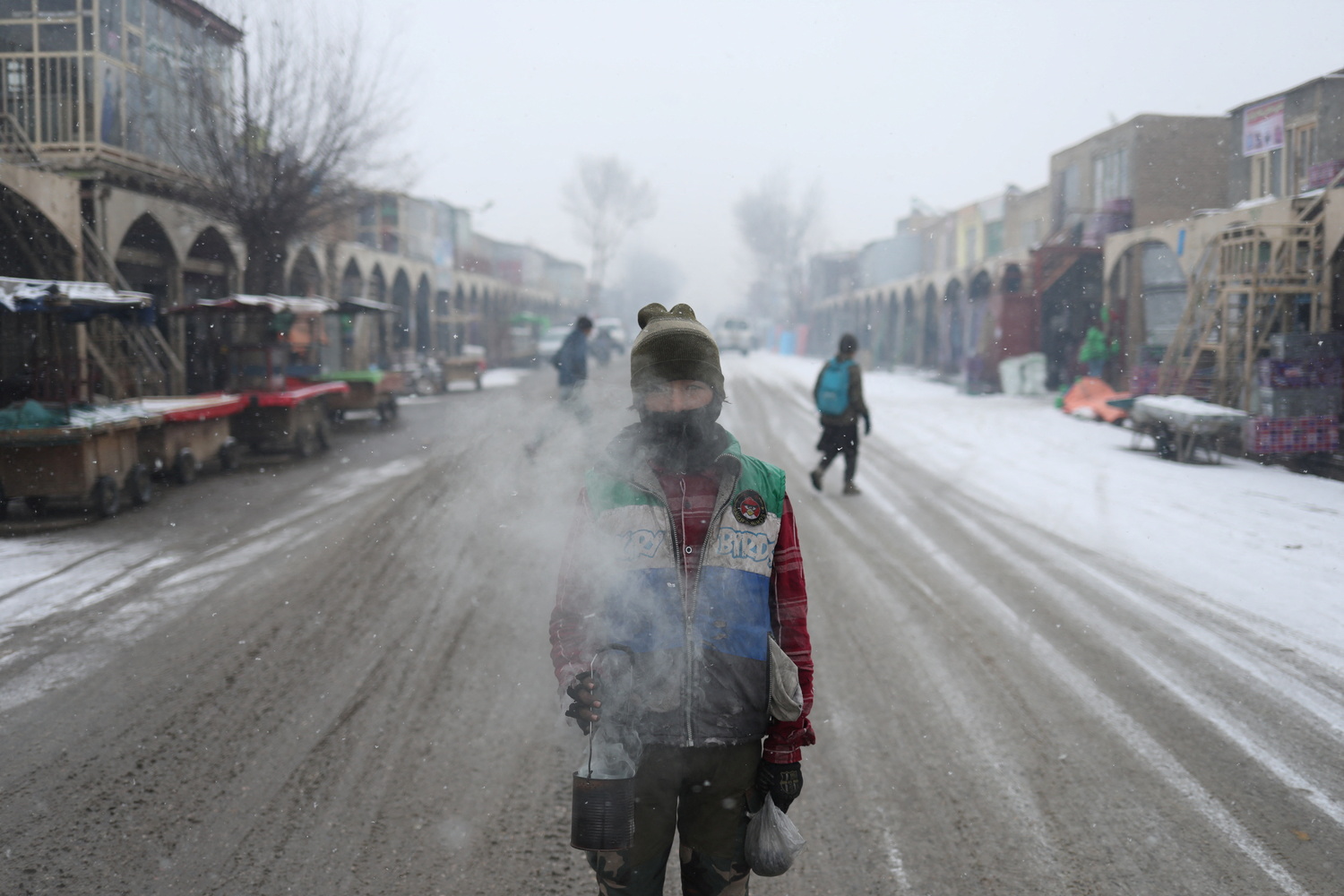 Rostam, poses for a photograph on a snowy road in Bamiyan, Afghanistan