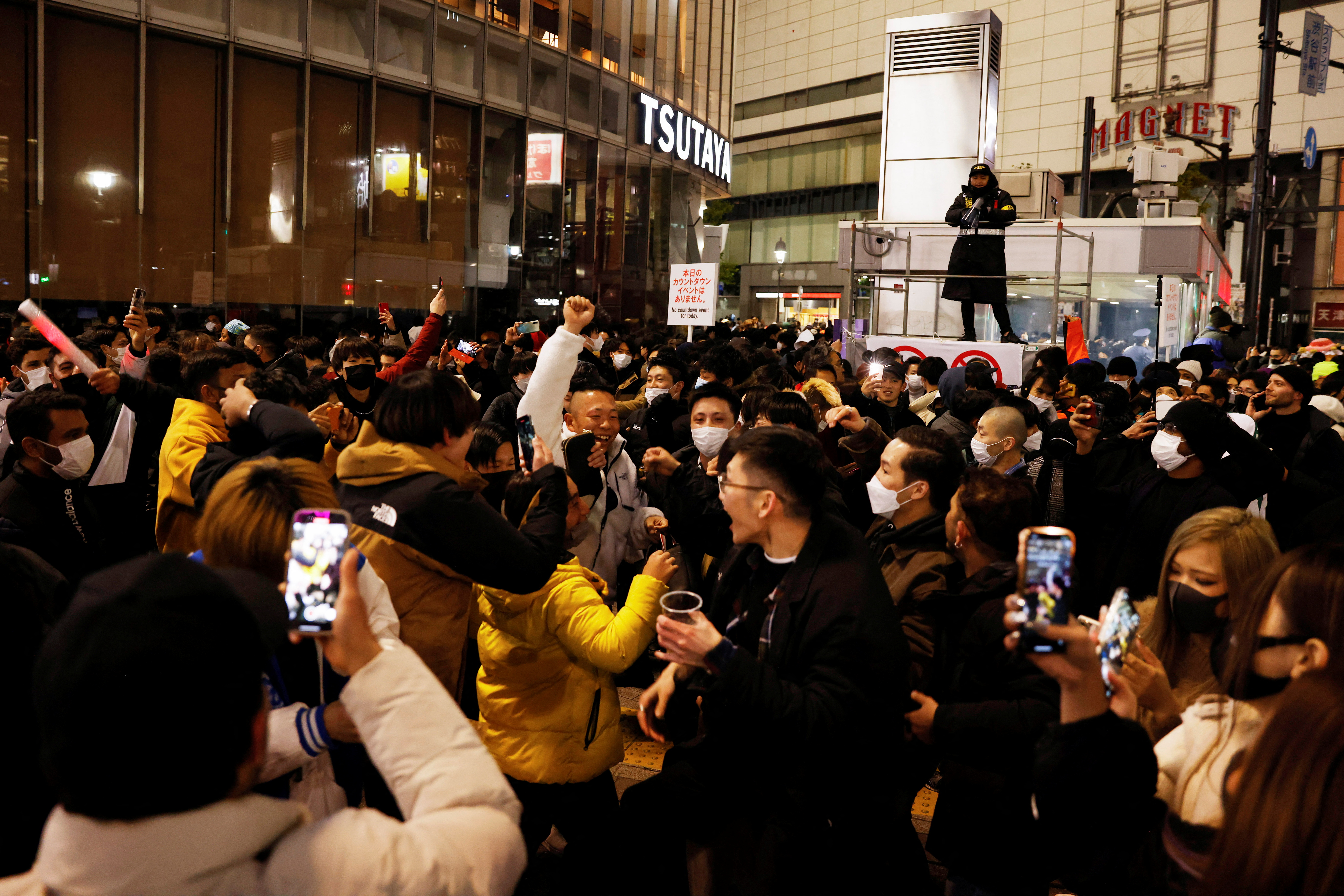 People celebrate outside at the Shibuya crossing in Tokyo, Japan