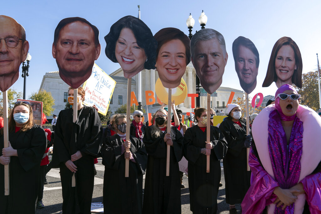 Abortion rights advocates hold cardboard cutouts of Supreme Court justices