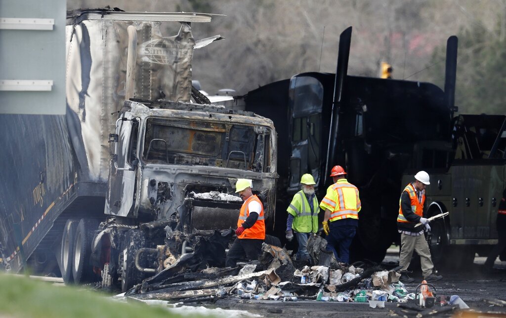 Workers clear debris from the aftermath of a deadly pileup on Interstate 70 in Lakewood Colorado