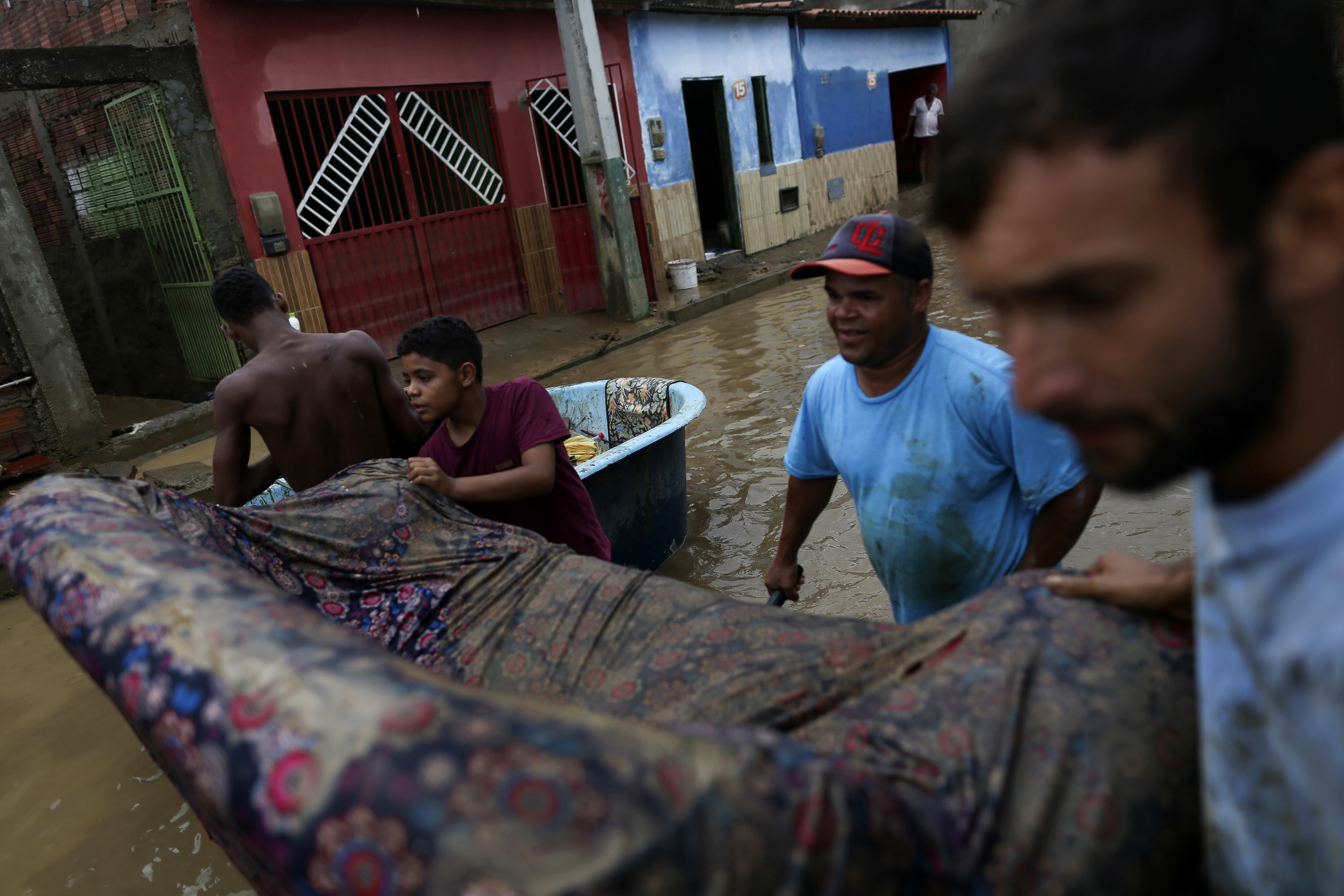 Residents clean out their flooded homes in Bahia state, Brazil