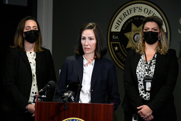 Jefferson County District attorney Alex King stands at a podium at a press conference