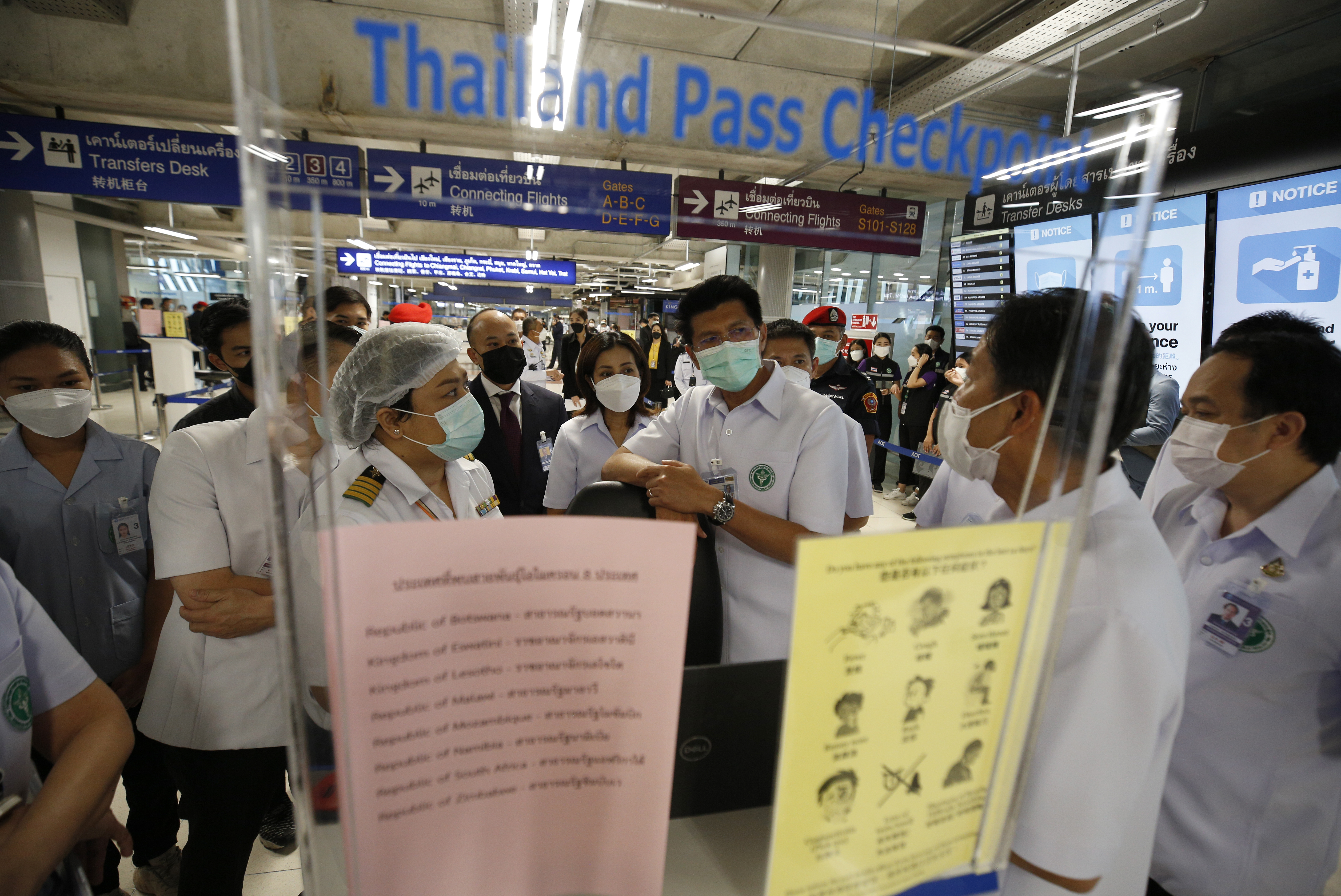 Thai deputy of Public Health Minister, Satit Pitutacha (C) talks to airport worker as visits the checkpoint for health screening protocol for international arriving passengers ?at Suvarnabhumi International Airport