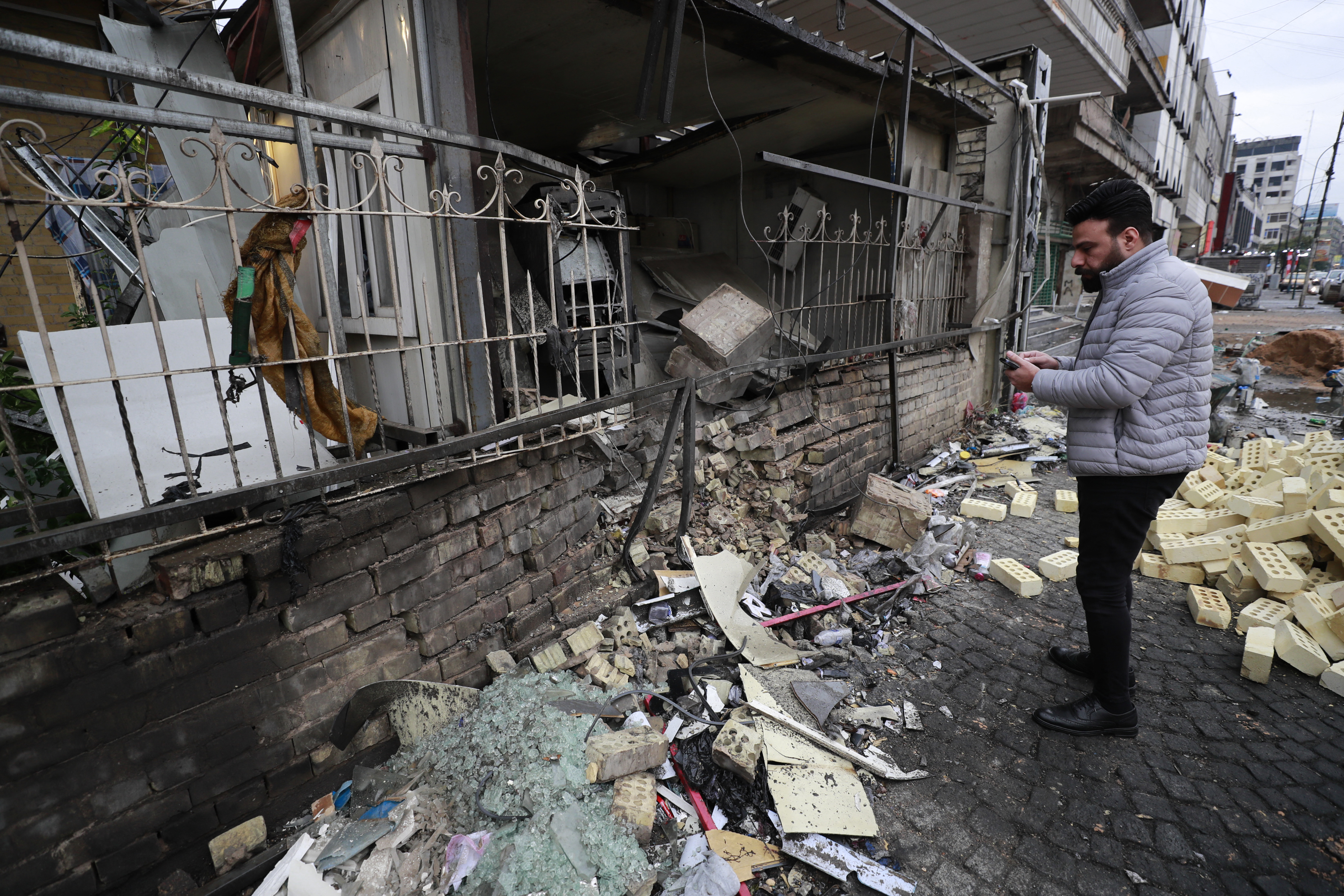 An Iraqi man checks the scene of an explosion outside the Kurdish Cihan Bank in the Karrada district of Iraq
