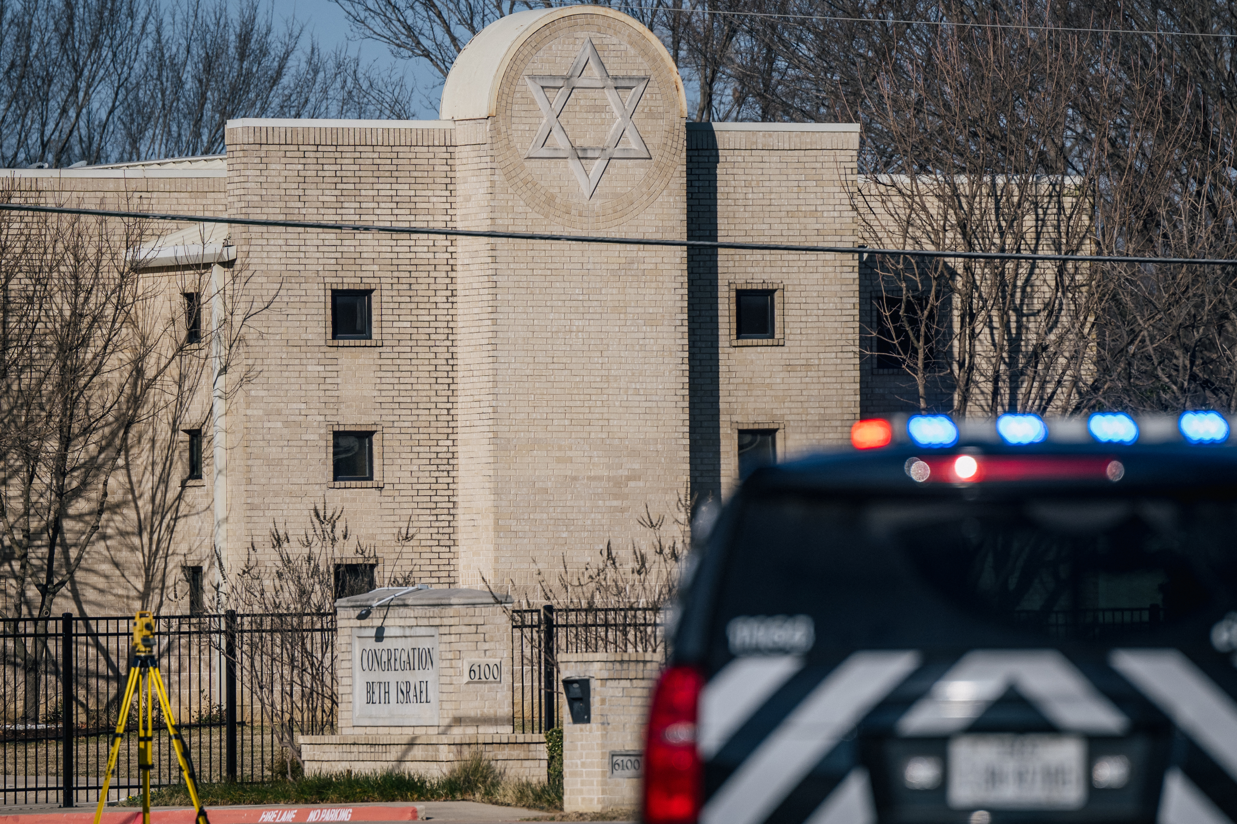 A police vehicle with flashing blue lights outside the synagogue in Colleyville