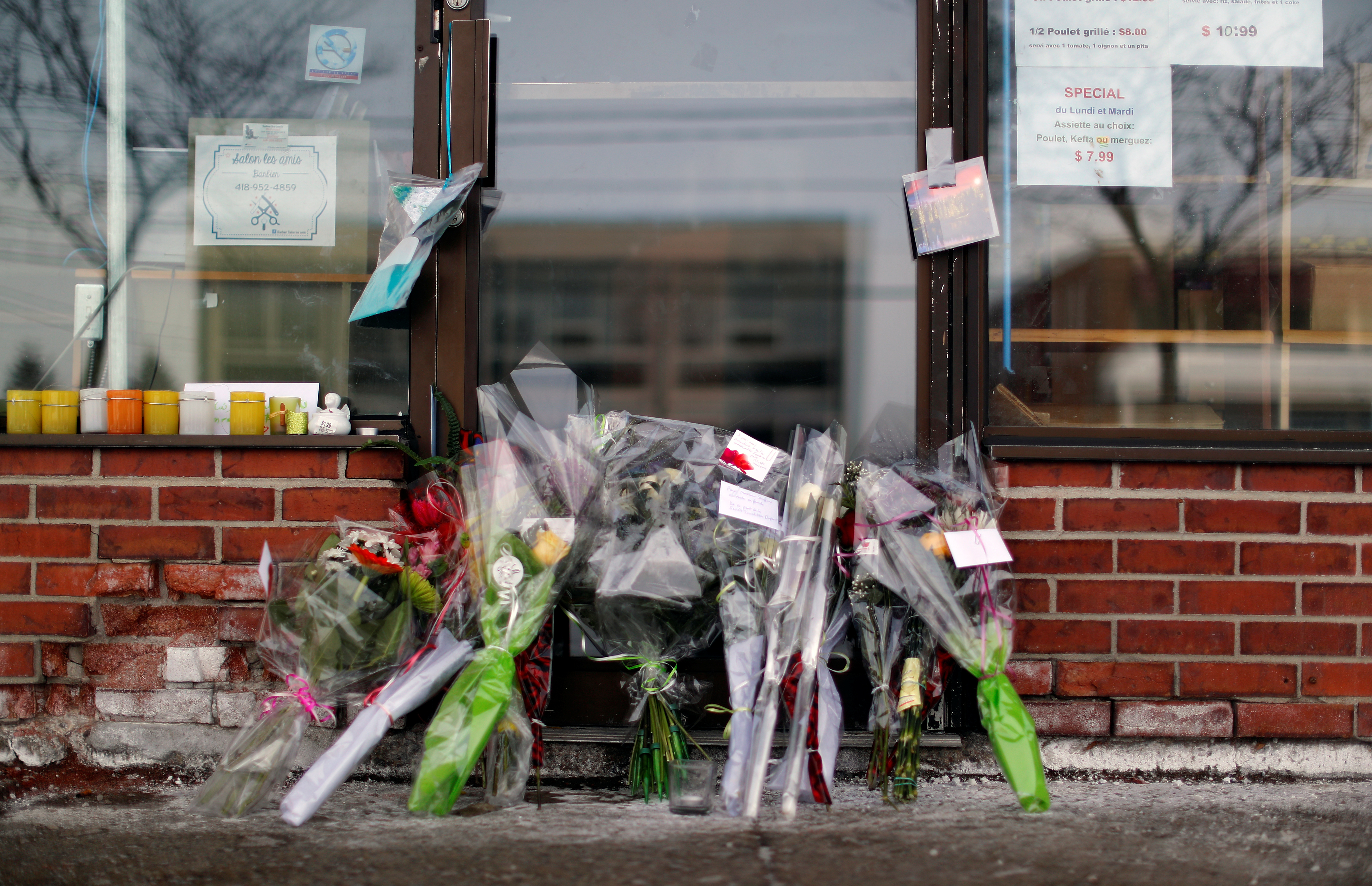 Flowers are pictured at the door to the grocery store owned by Azzedine Soufiane, killed in the mosque attack