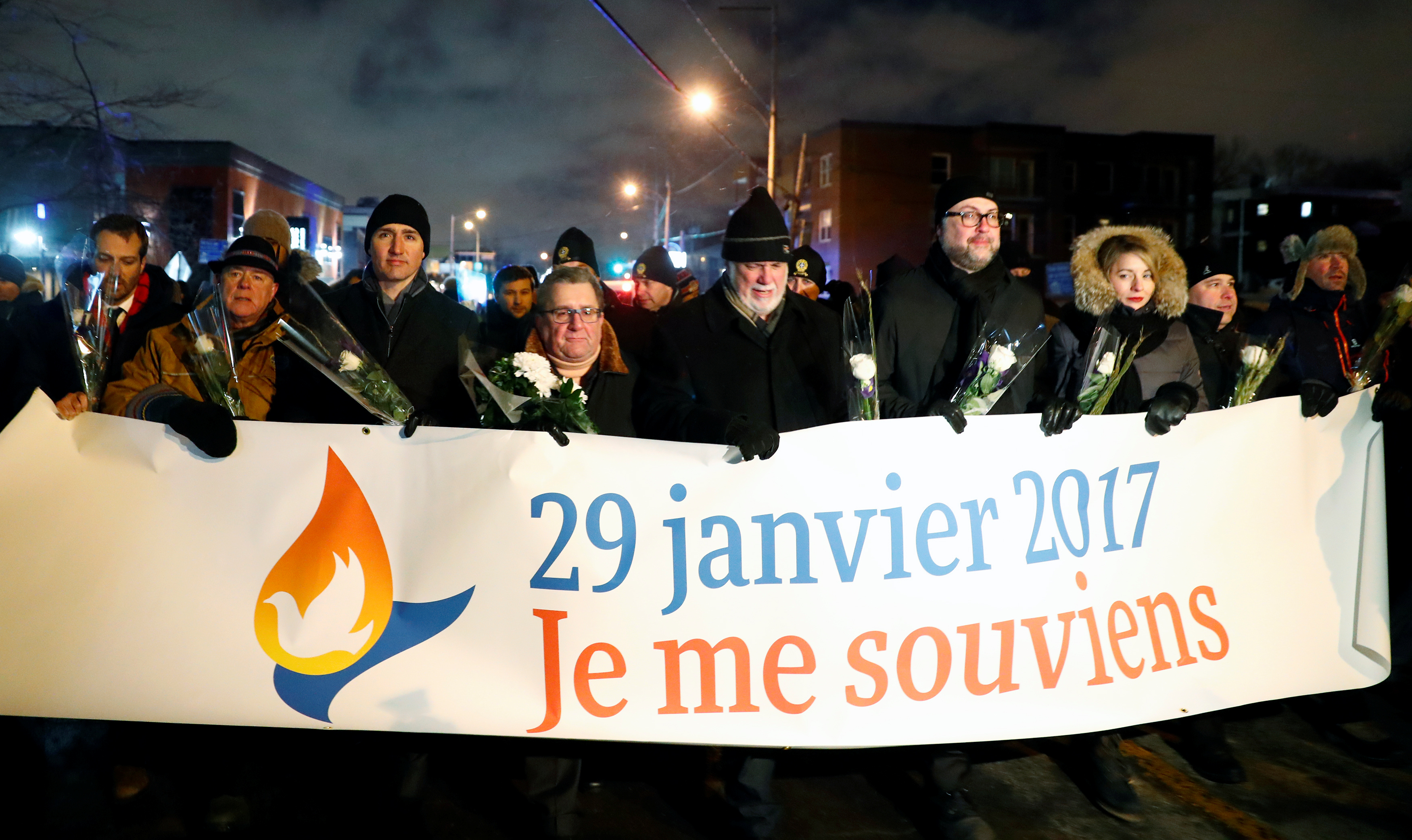 Canada's Prime Minister Justin Trudeau and Quebec's Premier Philippe Couillard hold a banner.
