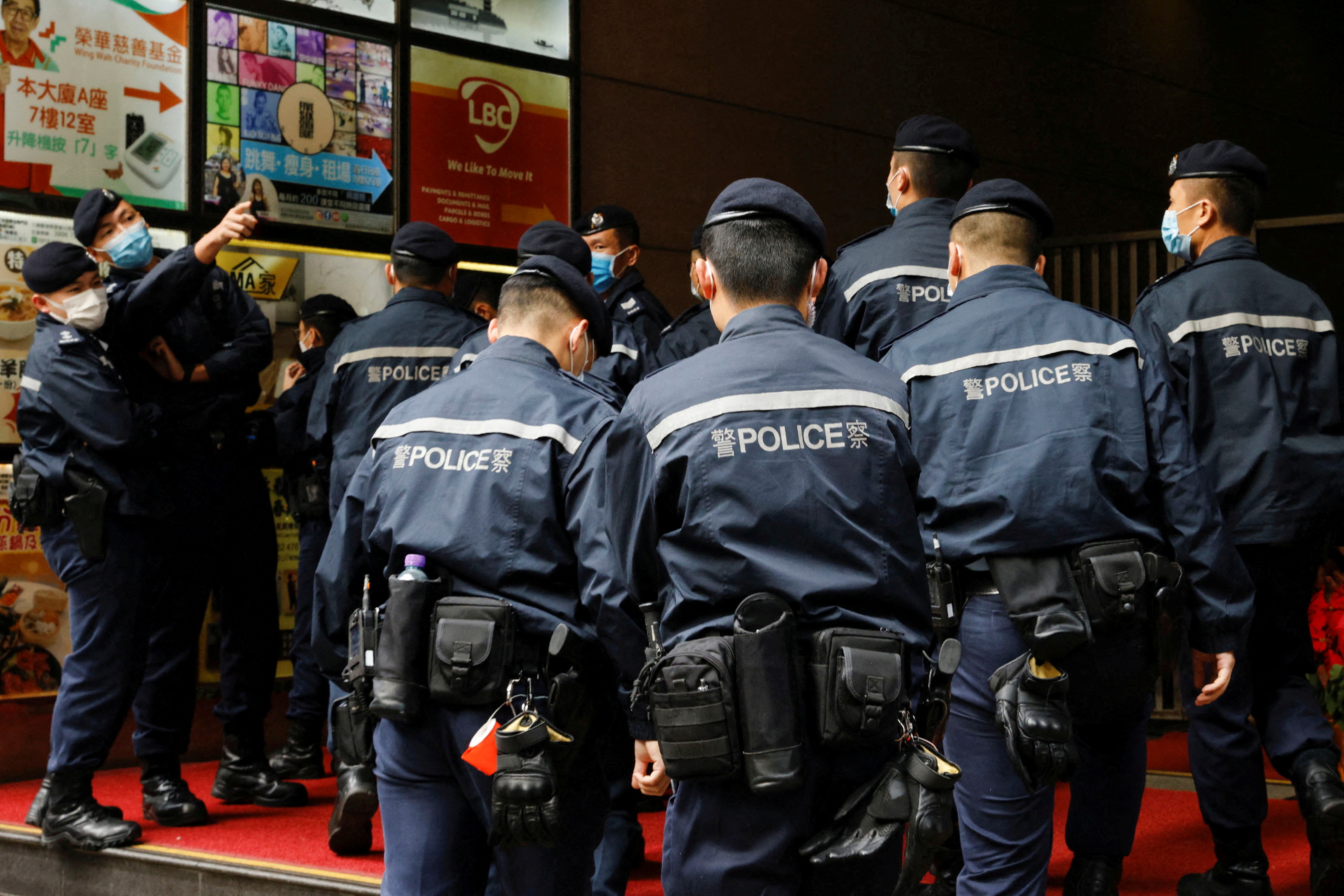 Police are seen outside the Stand News office building after six people were arrested on the charge of conspiracy to publish a seditious publication on December 29, 2021