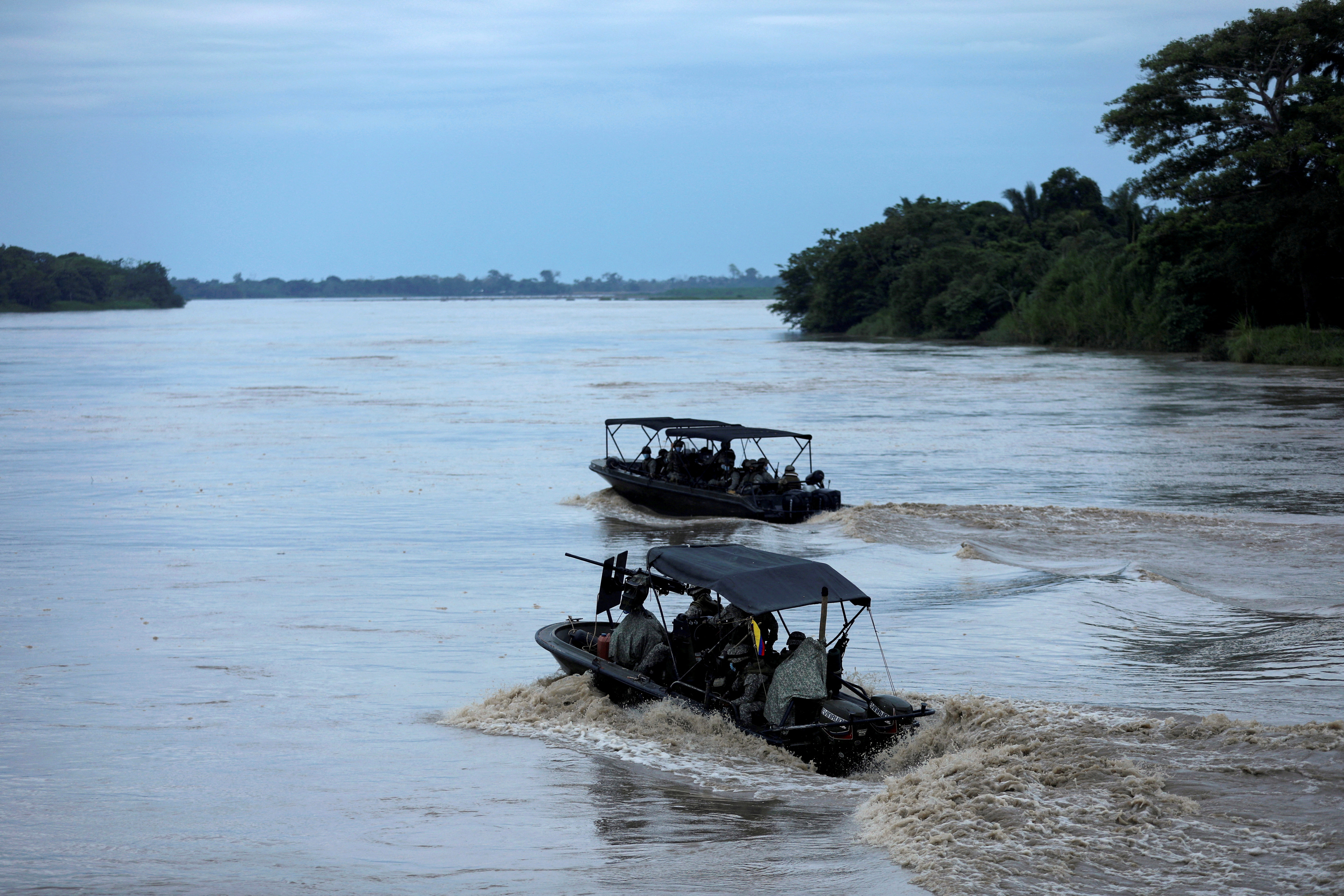 Colombian soldiers patrol by boat on the Arauca River, at the border between Colombia and Venezuela, as seen from Arauquita, Colombia on March 28, 2021 [File: Luisa Gonzalez/Reuters]