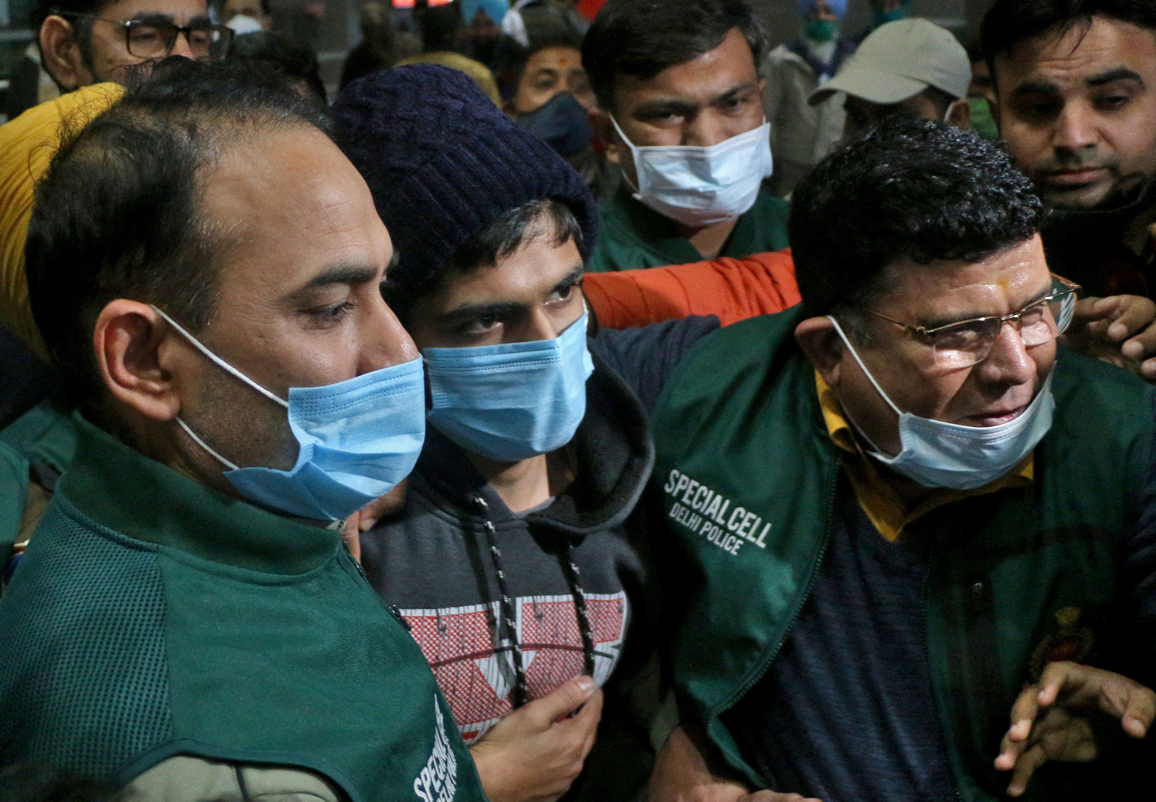 Police escort a 20-year-old man through New Delhi airport after he was arrested in the eastern state of Assam over allegedly creating an online app 'selling' Muslim women.