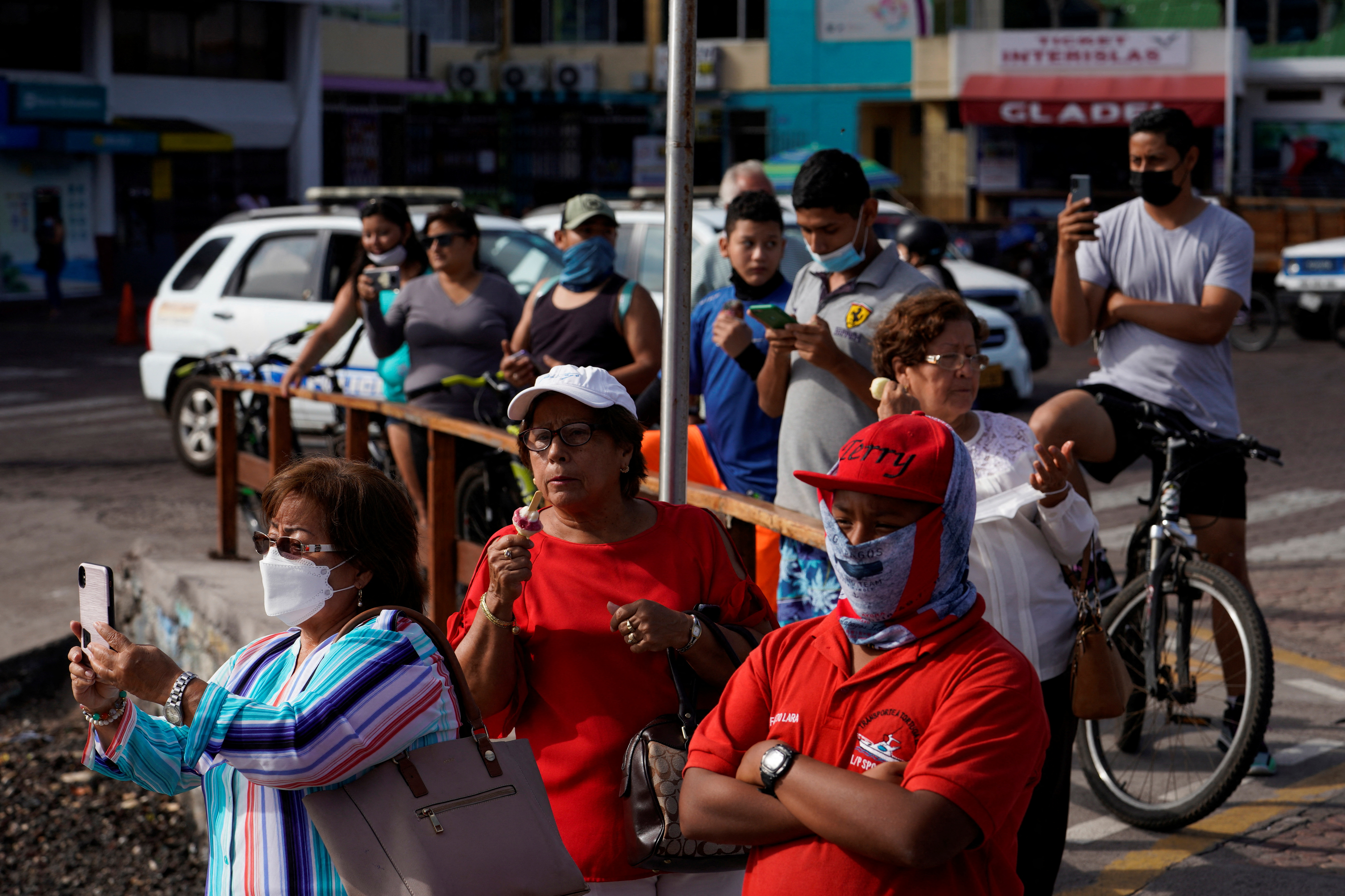 Locals watch the ocean to see if it rises after a volcanic eruption near Tonga generated a tsunami advisory