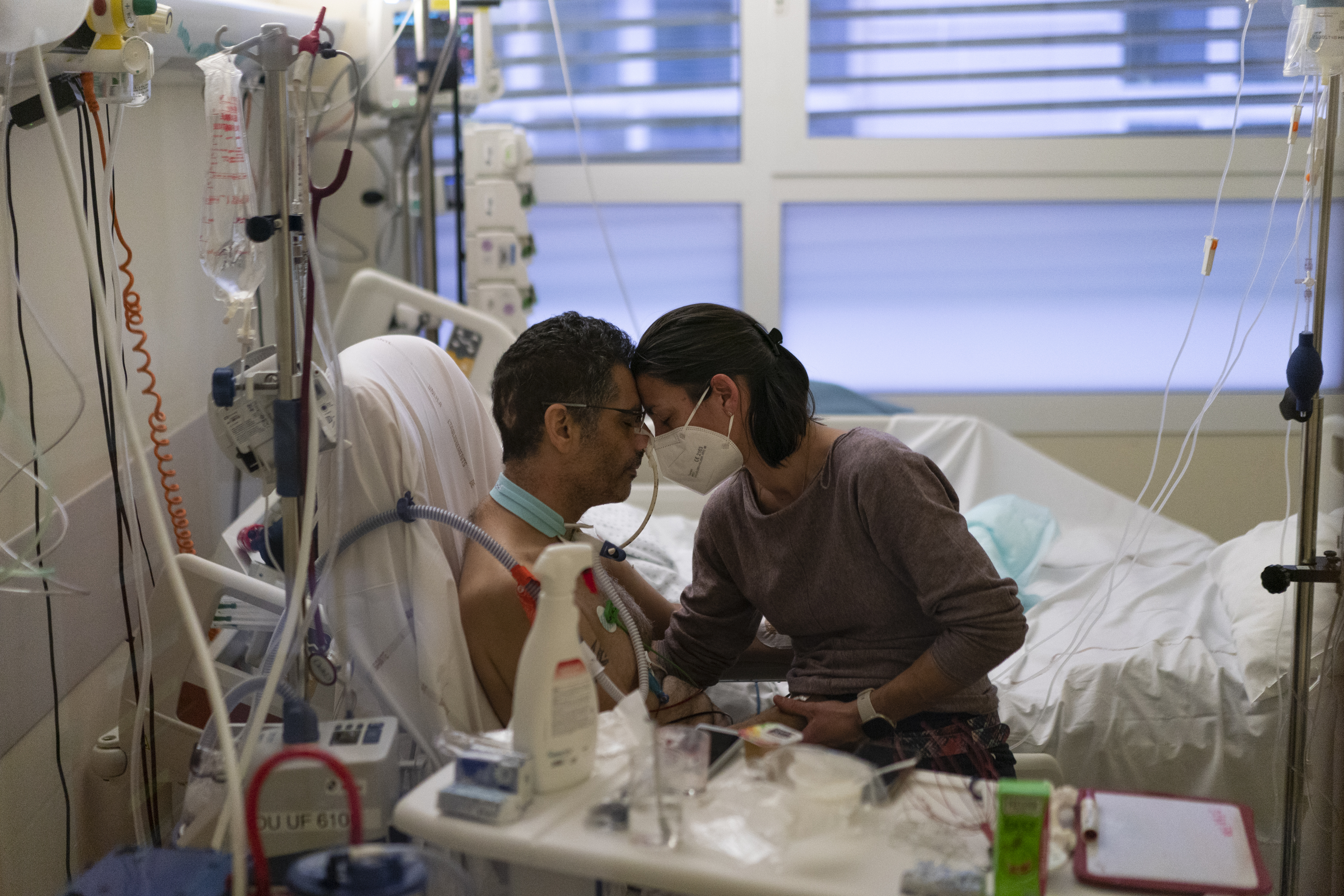 Amelie and Ludo Khayat hold each other during a visit at the COVID-19 intensive care unit of the la Timone hospital in Marseille, southern France, Thursday, December 23, 2021.