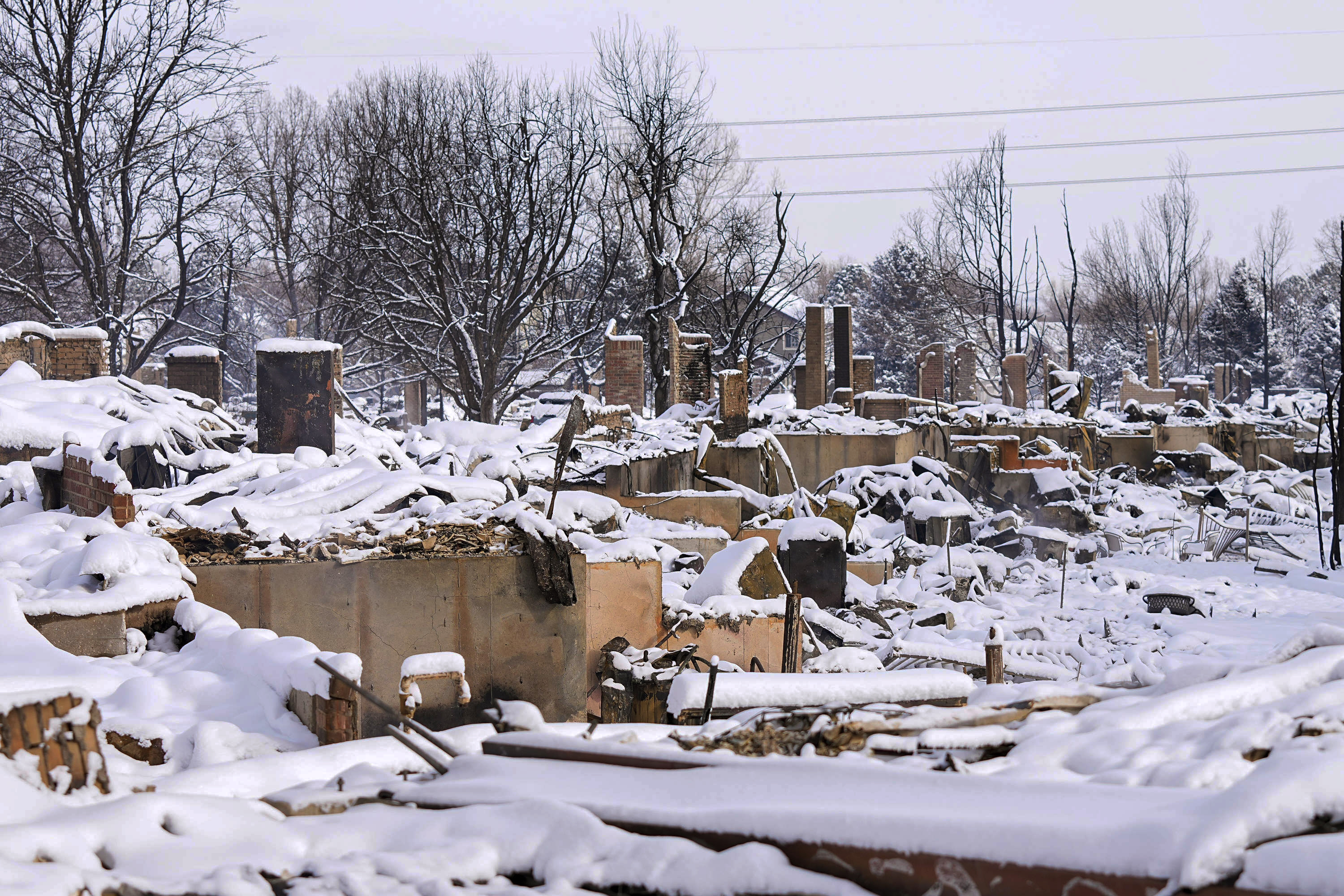 Snow covers the burned remains of homes after the Marshall Wildfire in Colorado