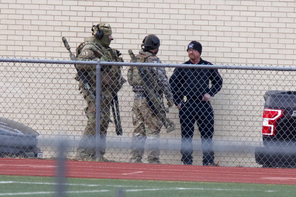 Heavily armed SWAT team members gathered at a local school in response to the hostage situation near the Congregation Beth Israel synagogue in Colleyville, Texas.