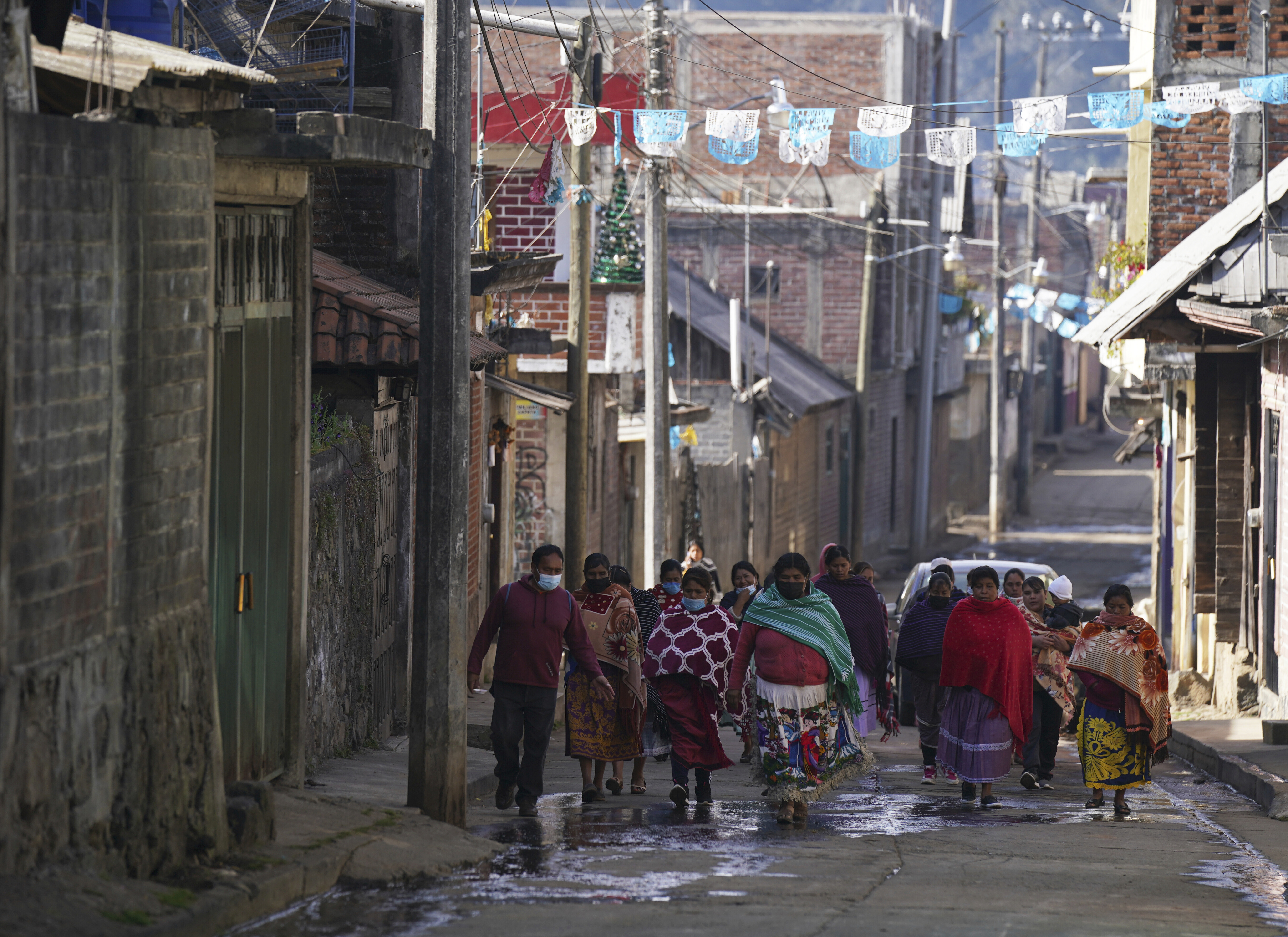 Women walk in the Puerpecha Indigenous community of Comachuen, Mexico