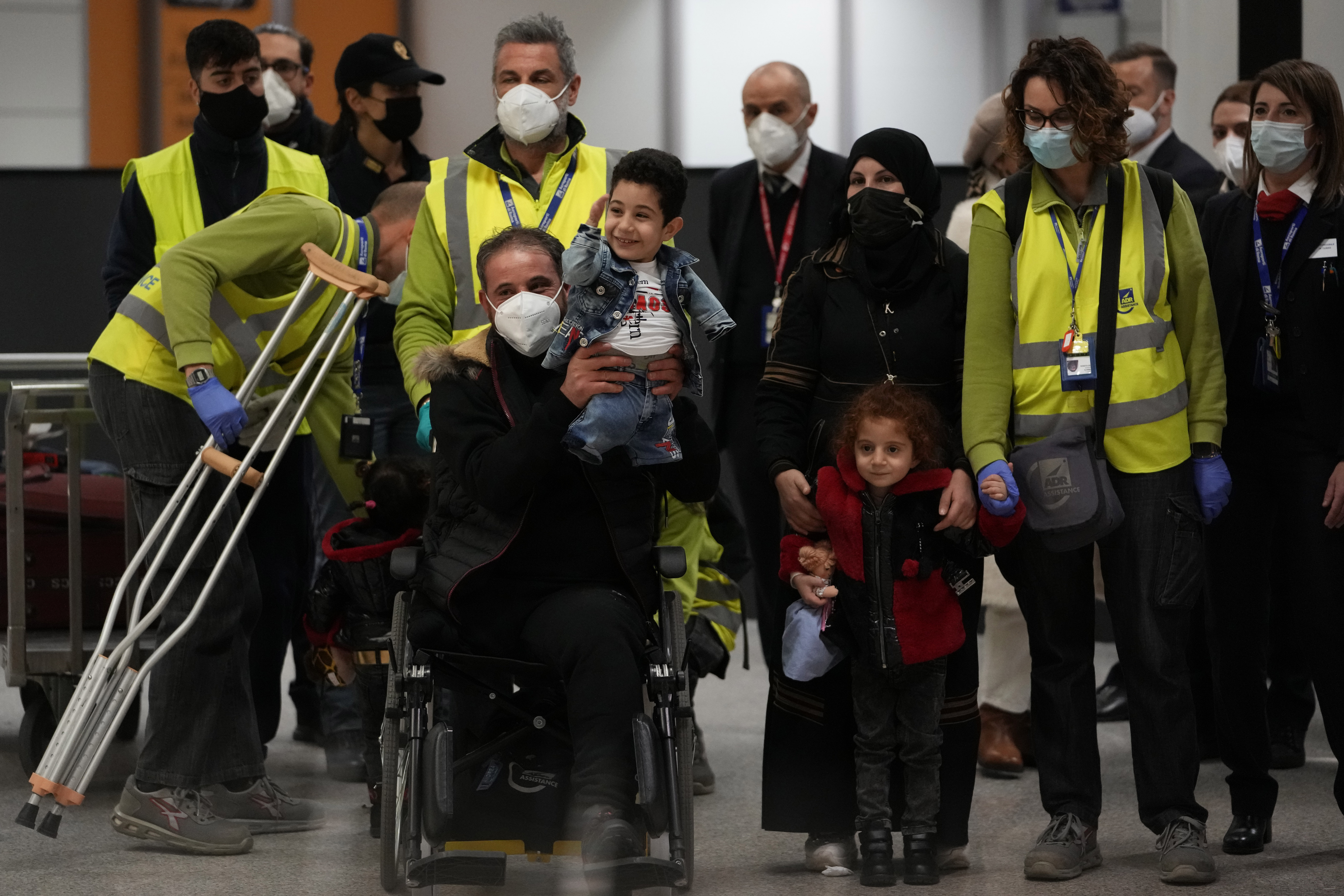 Munzir al-Nazzal, who lost his leg in the Syrian conflict, holds his son 5-year hold Mustafa, upon their arrival at Fiumicino's Leonardo Da Vinci airport
