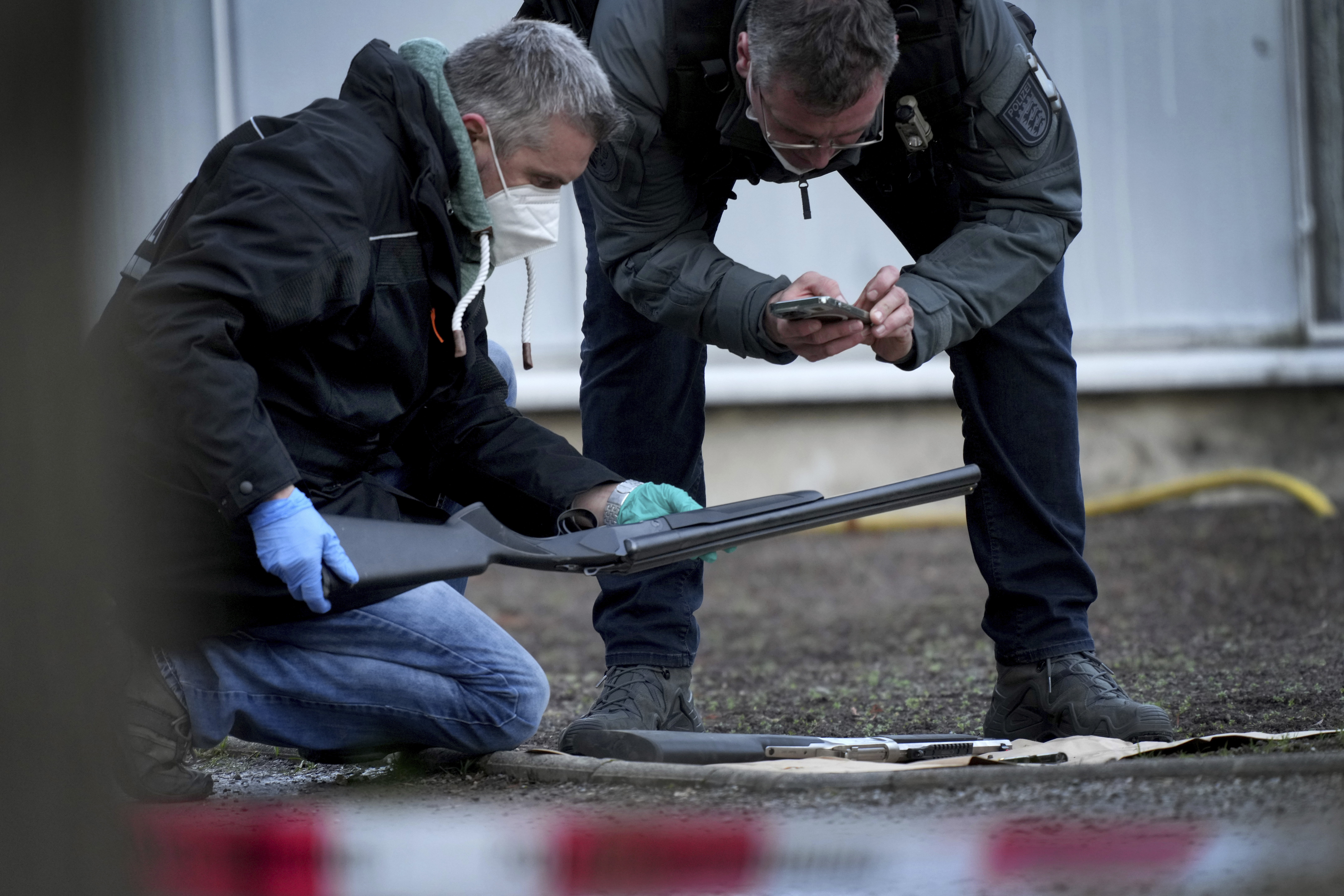 Police officers secure traces on the grounds of the Heidelberg University Botanical Garden in Heidelberg, Germany, Monday, Jan. 24, 2022. German police say a lone gunman wounded several people at a lecture theatre in the southwest city of Heidelberg on Monday. Police said in a brief statement that the perpetrator was dead but didn't give details of how that happened.