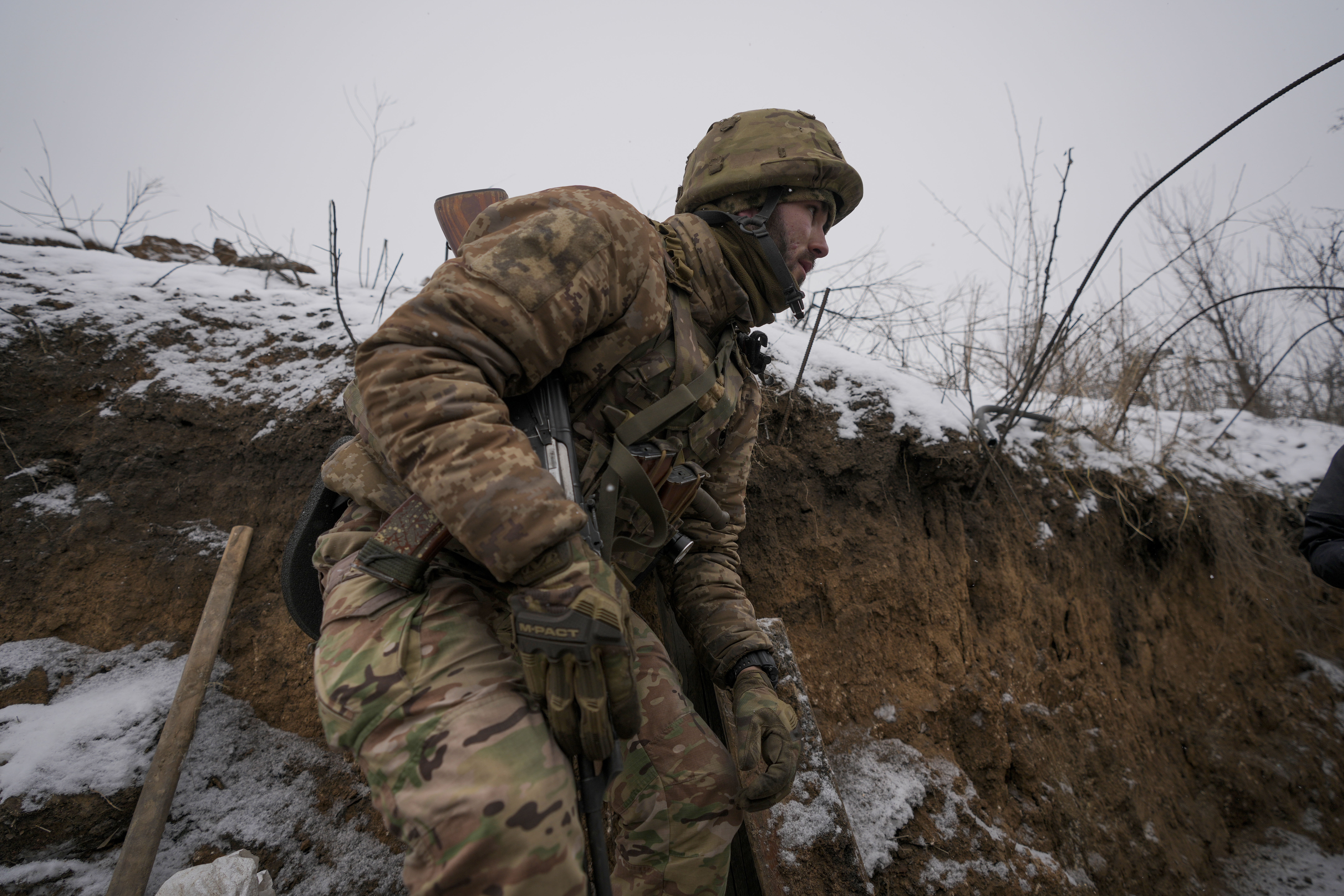 A Ukrainian serviceman ducks in a trench on the front line in the Luhansk region, eastern Ukraine, Friday, Jan. 28, 2022.
