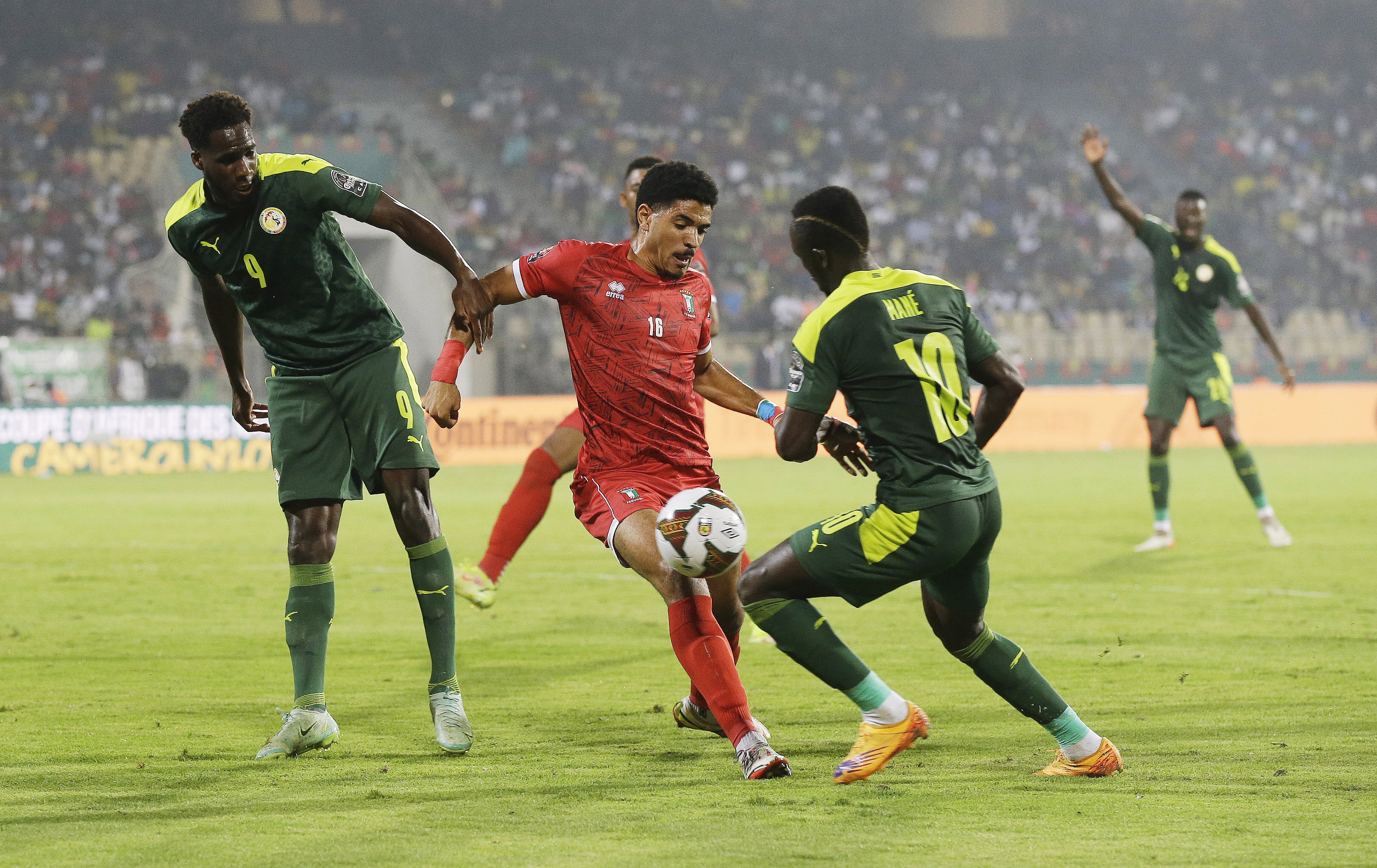 Senegal's Sadio Mane, right, vies for the ball with Equatorial Guinea's Emilio Nsue, center, during the African Cup of Nations 2022 quarter-final soccer match between Senegal and Equatorial Guinea at the Ahmadou Ahidjo stadium in Yaounde, Cameroon, Sunday, Jan. 30, 2022. (AP Photo/Sunday Alamba)
