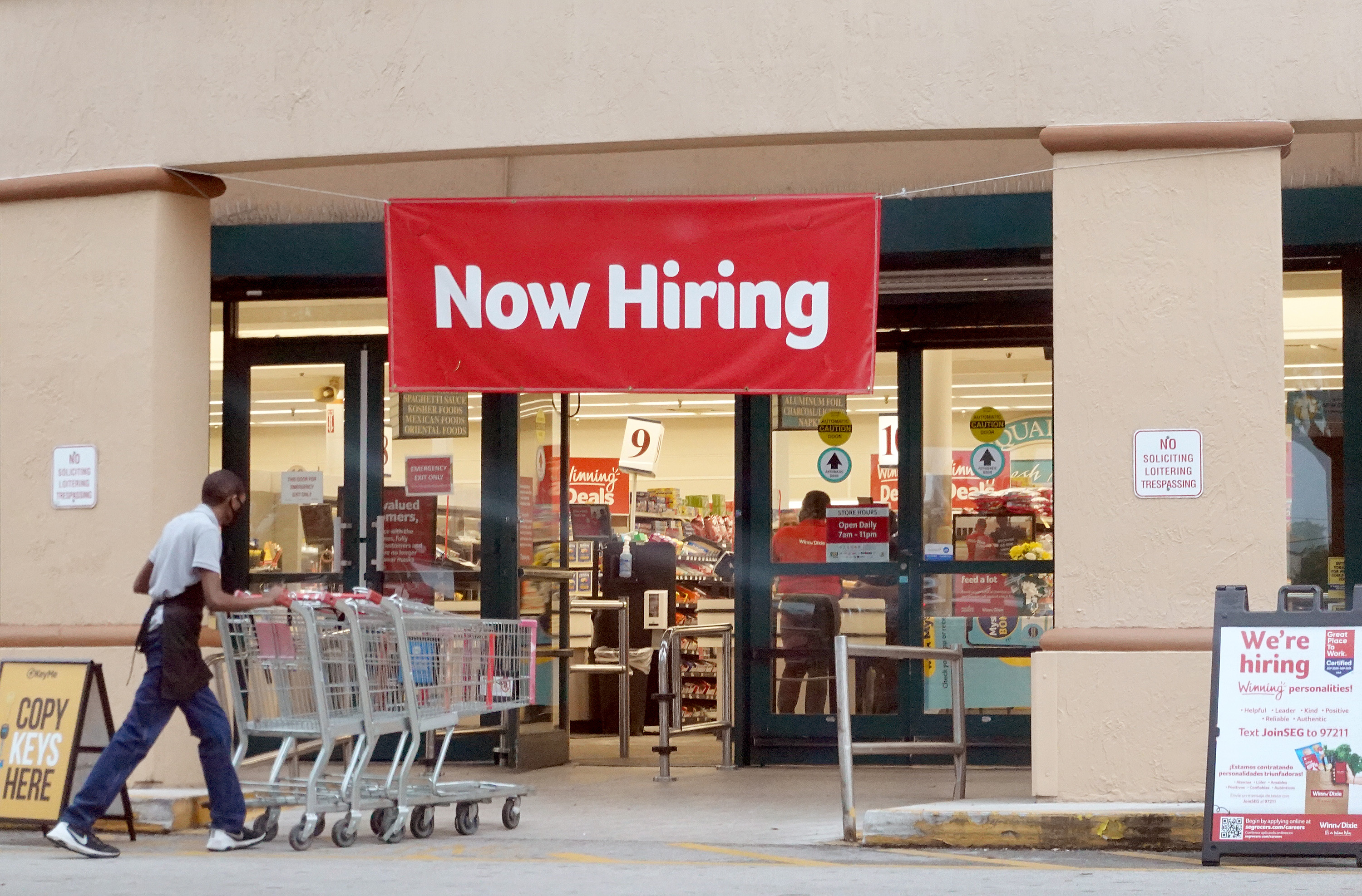 "Now hiring" sign in shop window