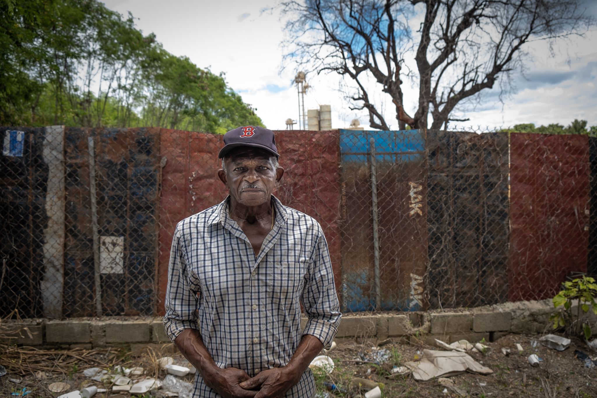 Ramon German, 81, stands in front of the area used for dumping rotting fruit