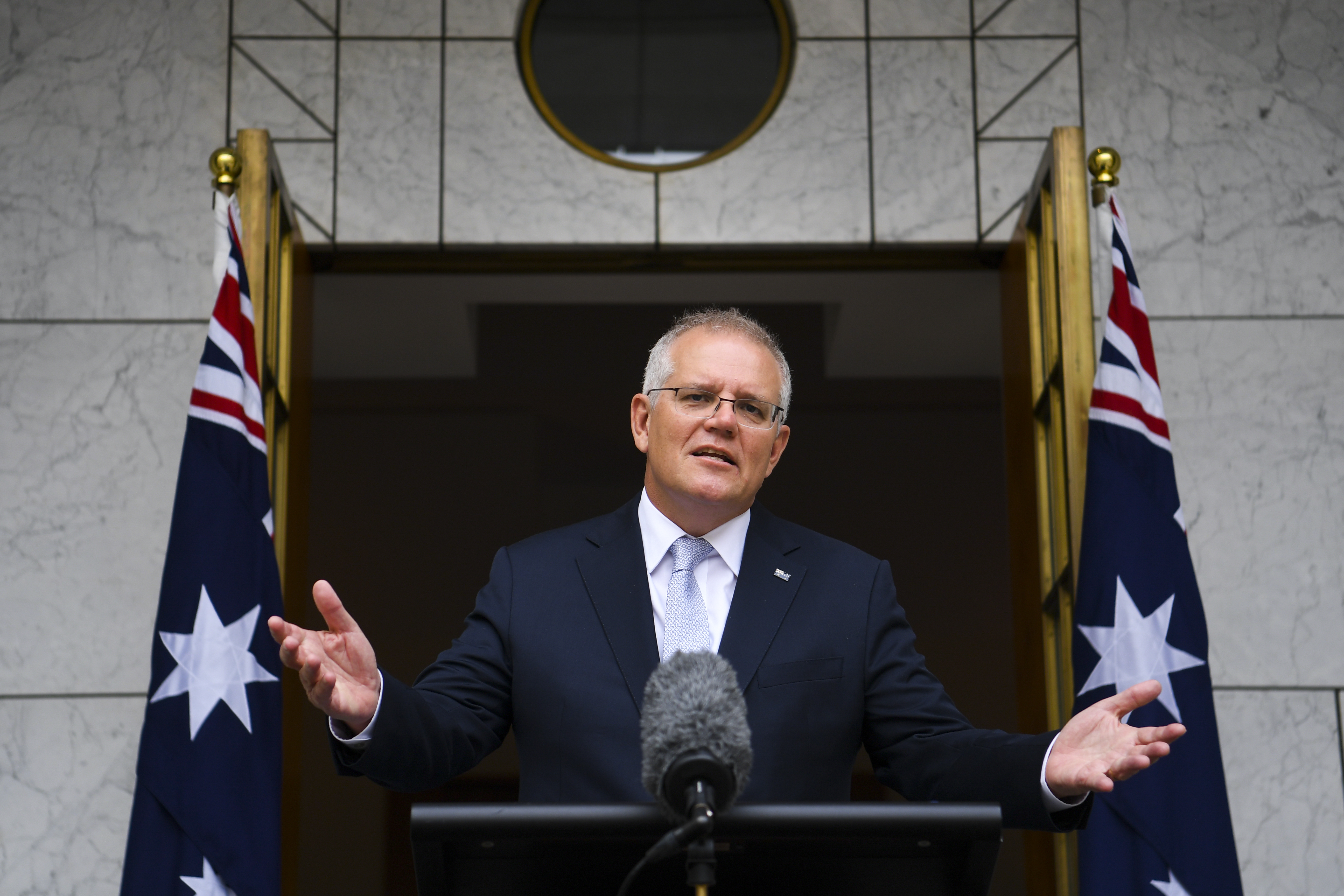 Australian PM Scott Morrison holds his hands out as he speaks to reporters in Canberra