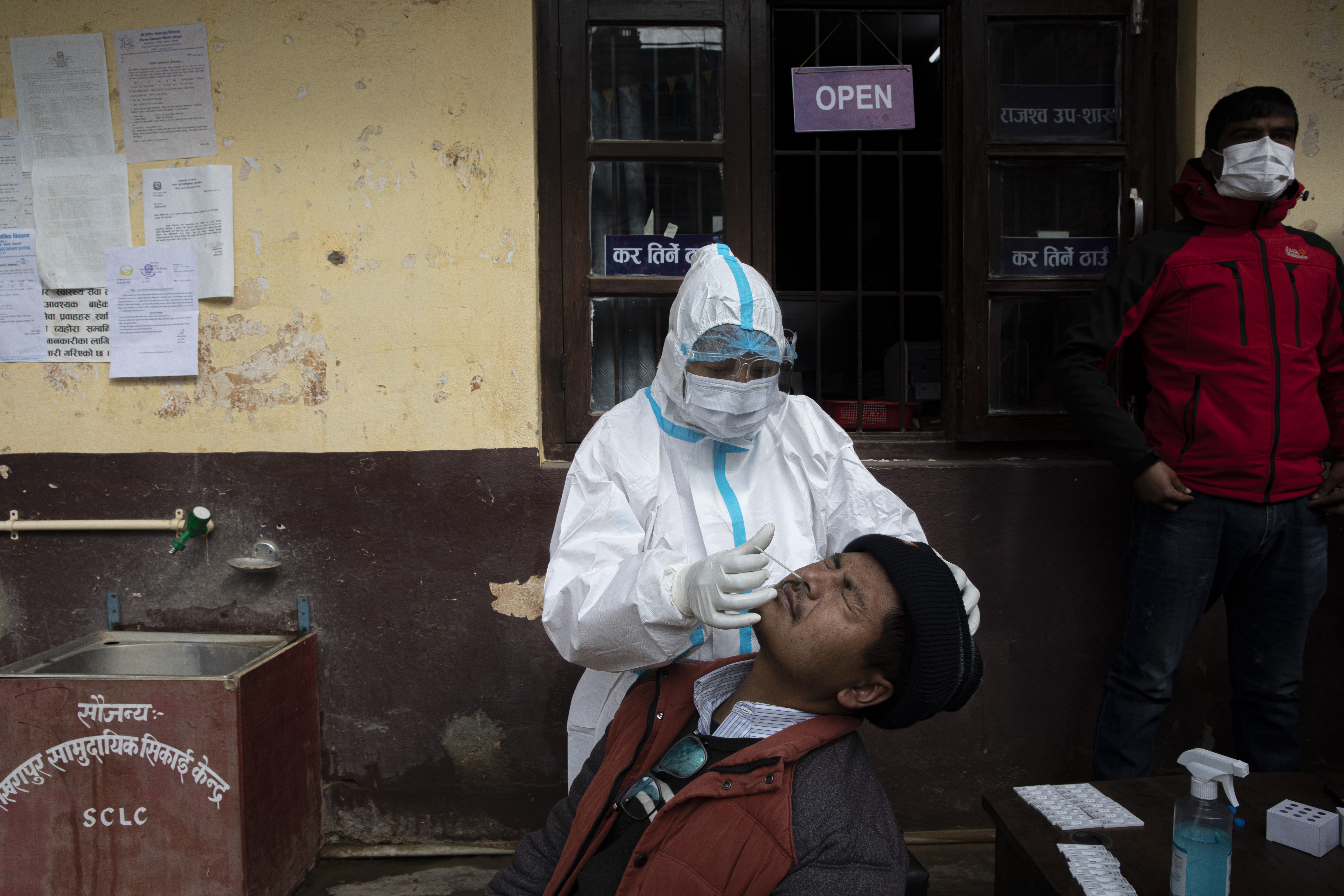 A Nepalese man reacts as health worker collects swab sample