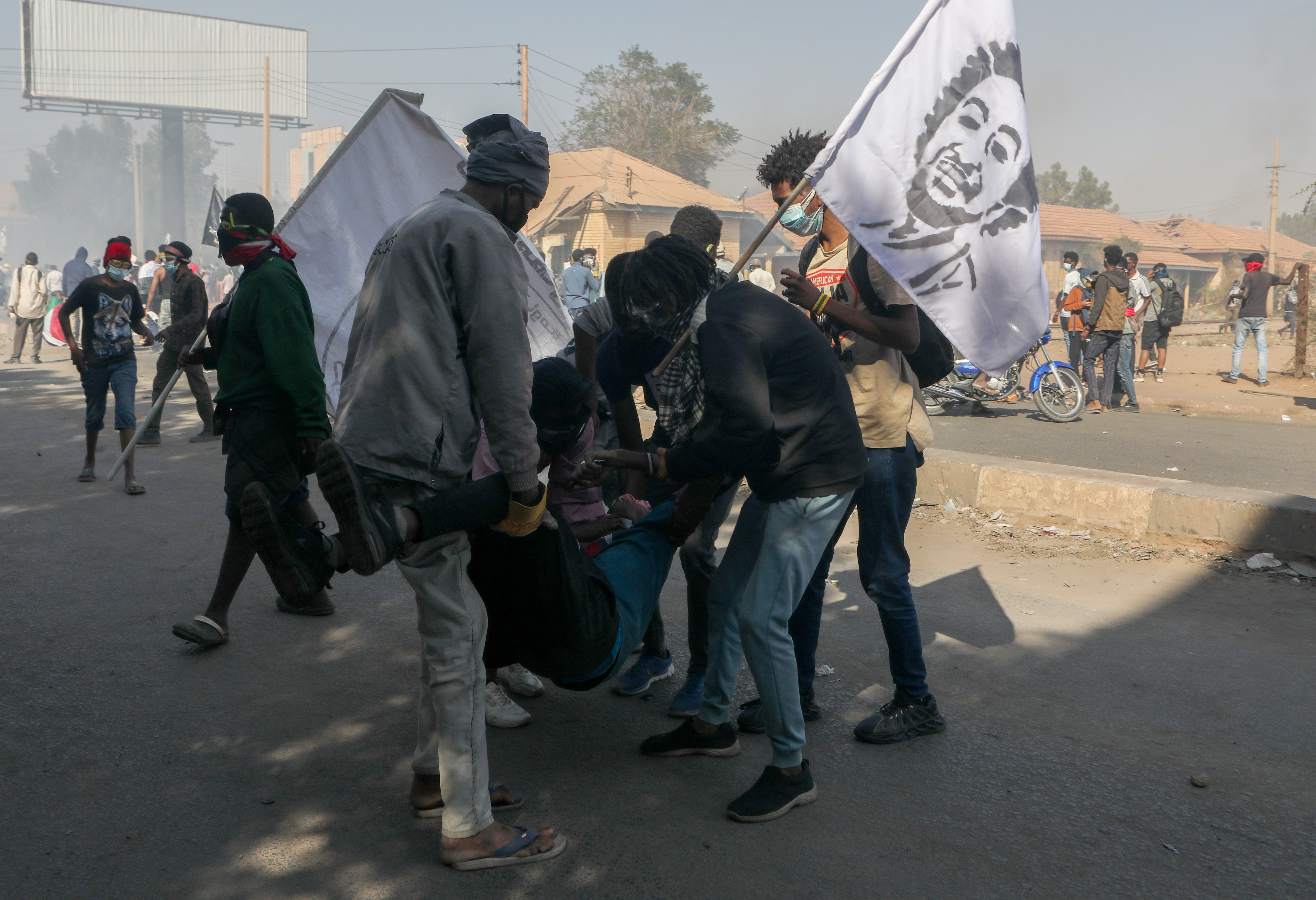 Sudanese people assist a fellow protester during clashes with security forces at a protest against military coup, in Khartoum, Sudan, 30 January 2022.