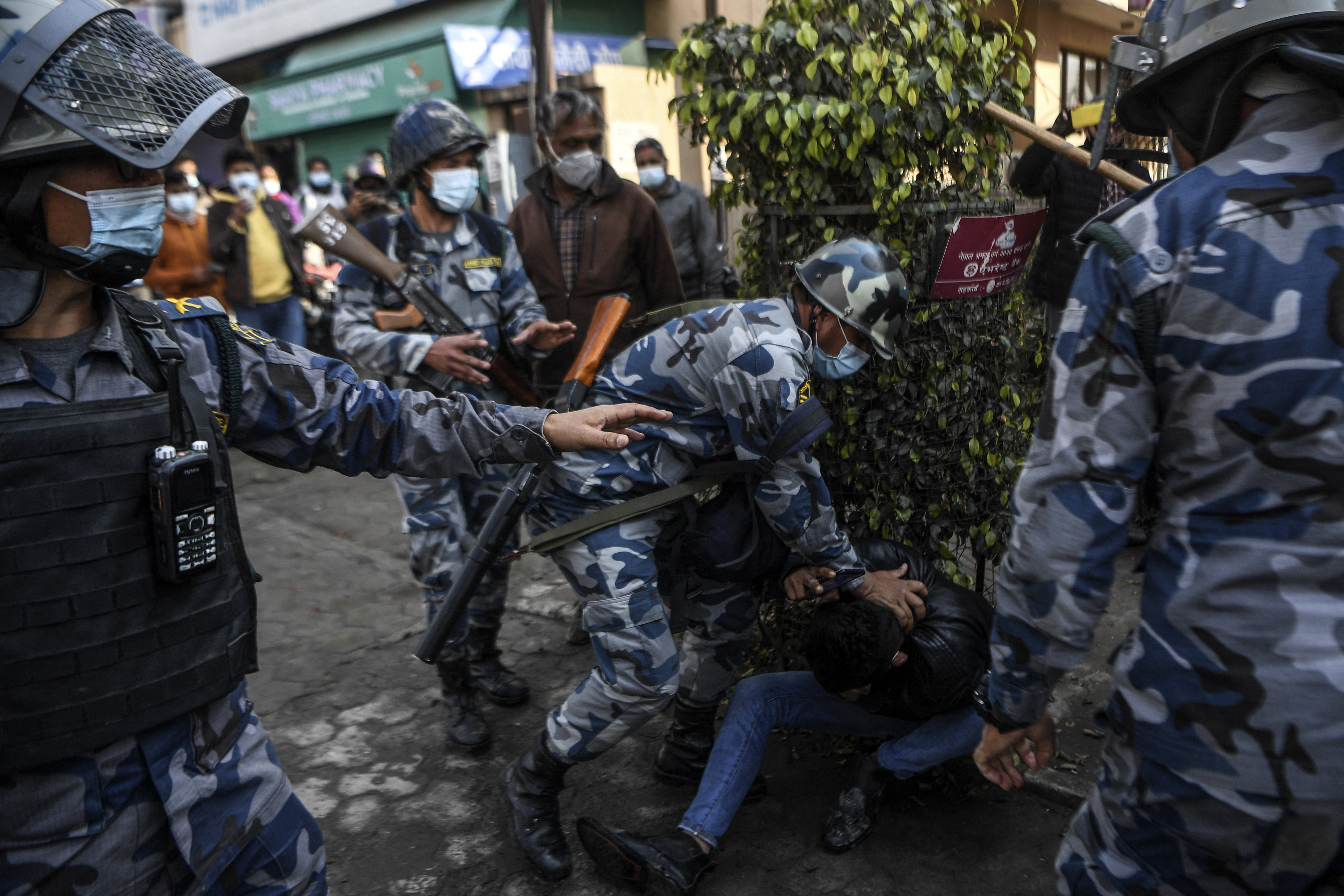 Police personnel detain a demonstrator