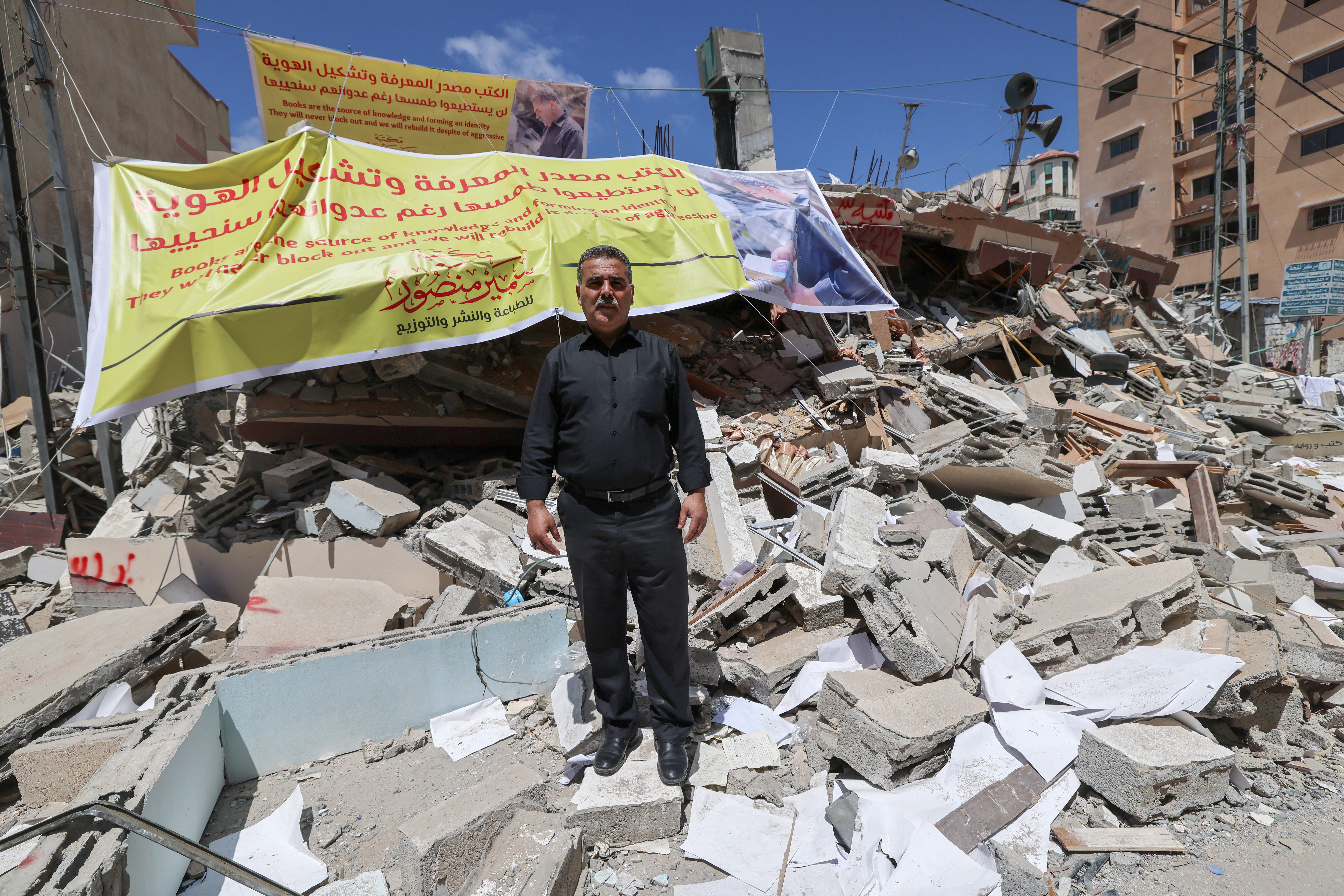 A man stands in the rubble of a destroyed bookstore in Gaza