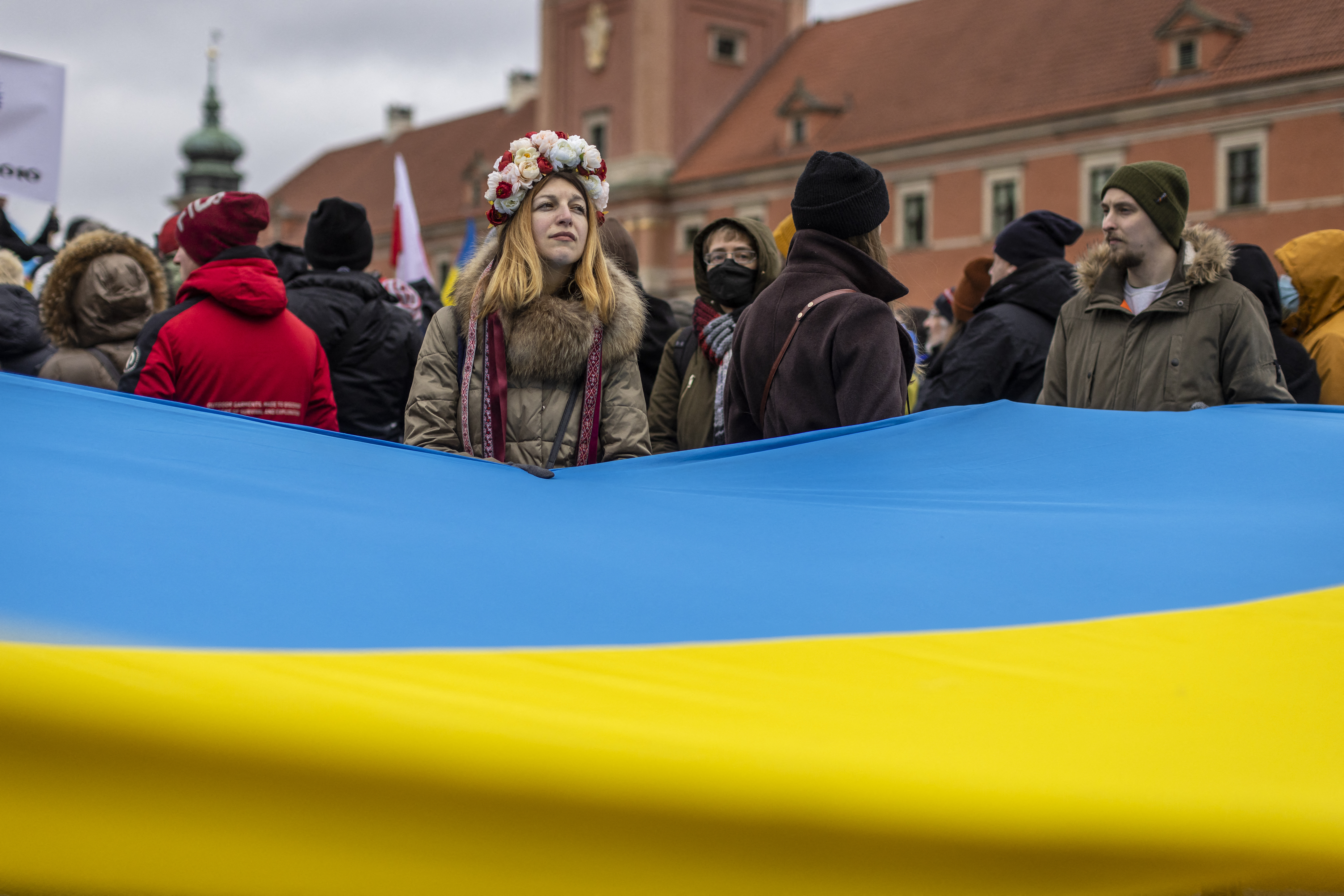 Protesters wave Ukrainian and Polish flags during a demonstration for peace 