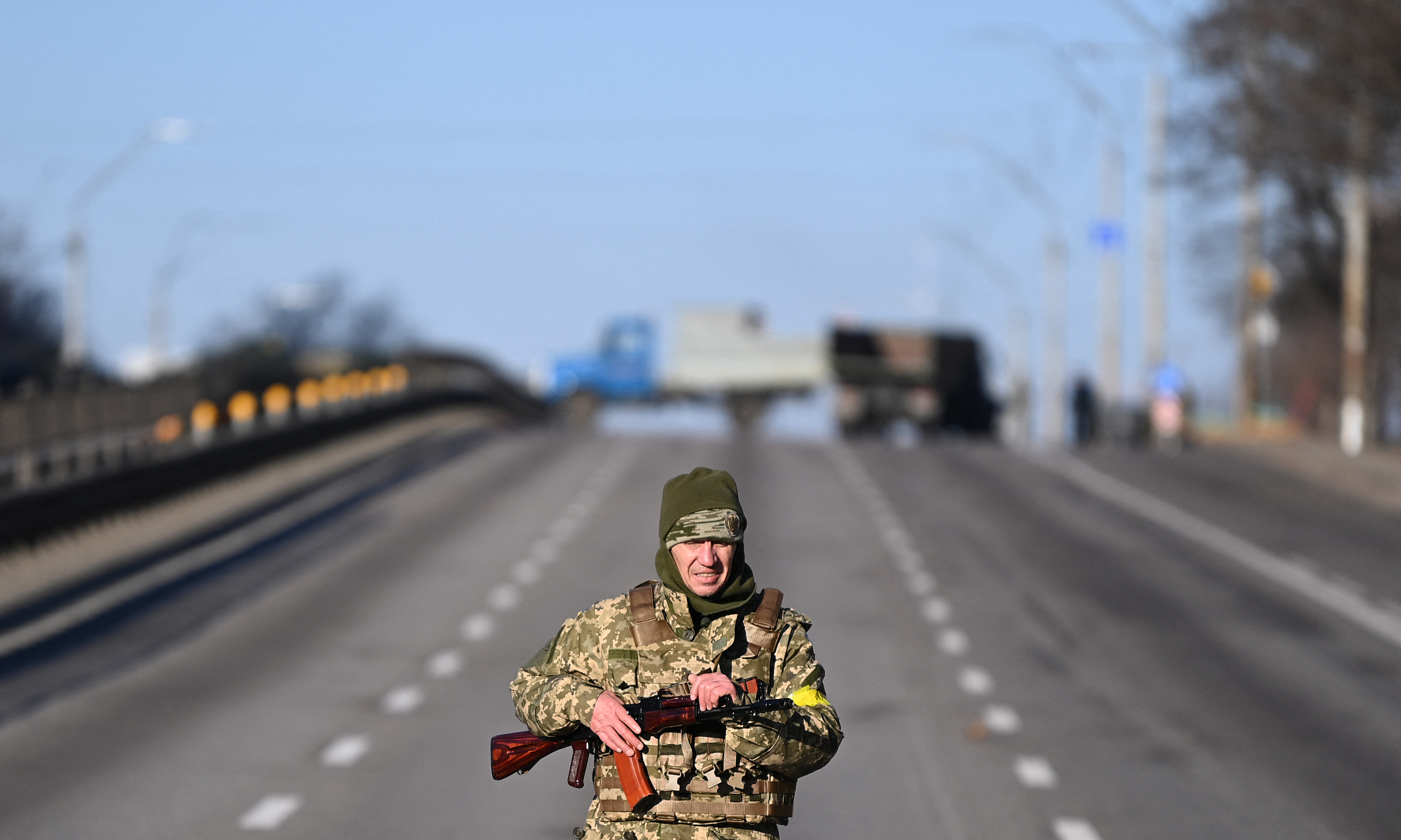 An Ukrainian service member patrol the empty road on west side of the Ukrainian capital of Kyiv in the morning of February 26, 2022. - Ukrainian soldiers beat back a Russian attack in the capital Kyiv only hours after President Volodymyr Zelensky warns Moscow would attempt to take the city before dawn. (Photo by Daniel LEAL / AFP)