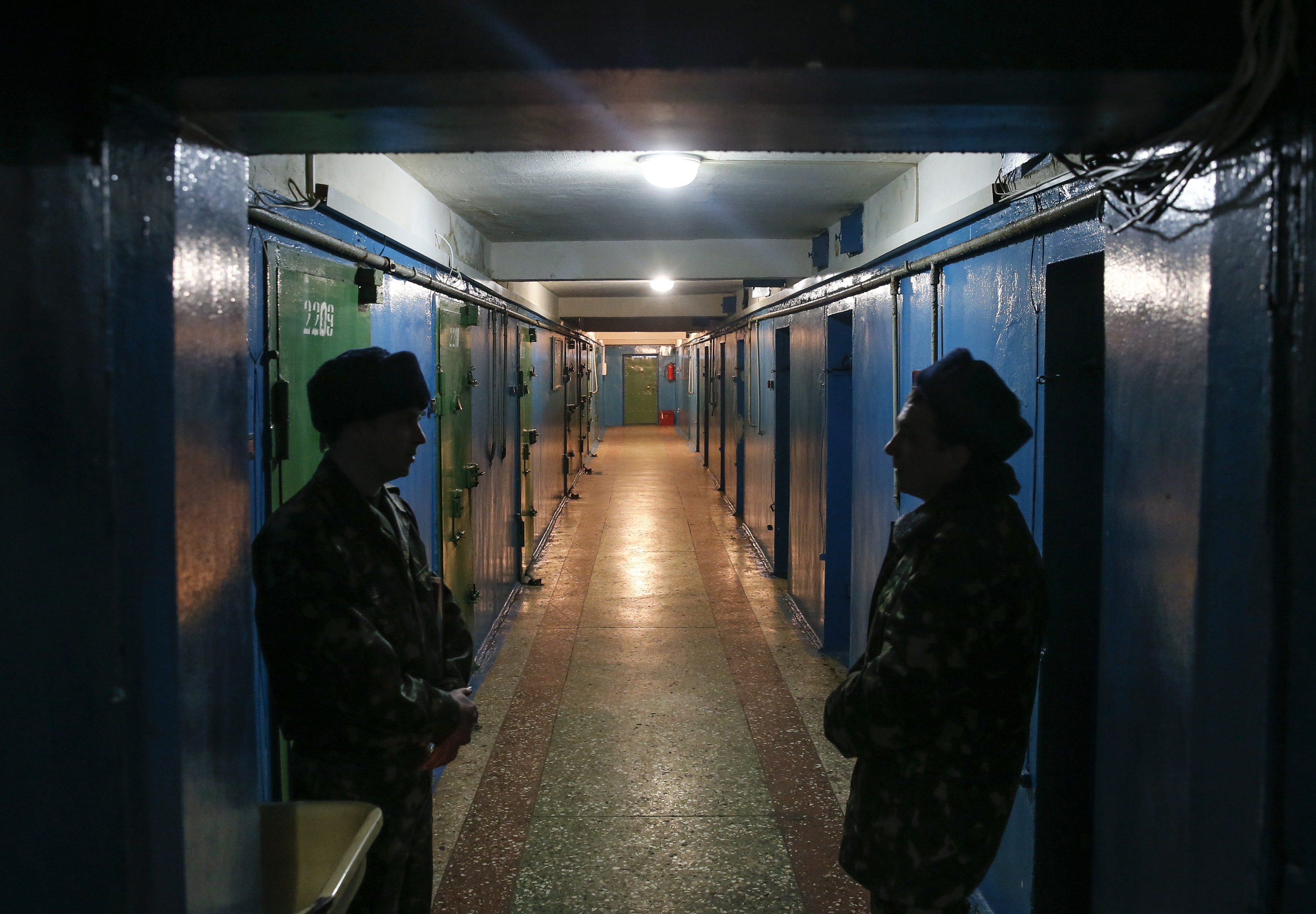 Donetsk remand prison employees stand guard along a corridor at a remand prison in Donetsk,