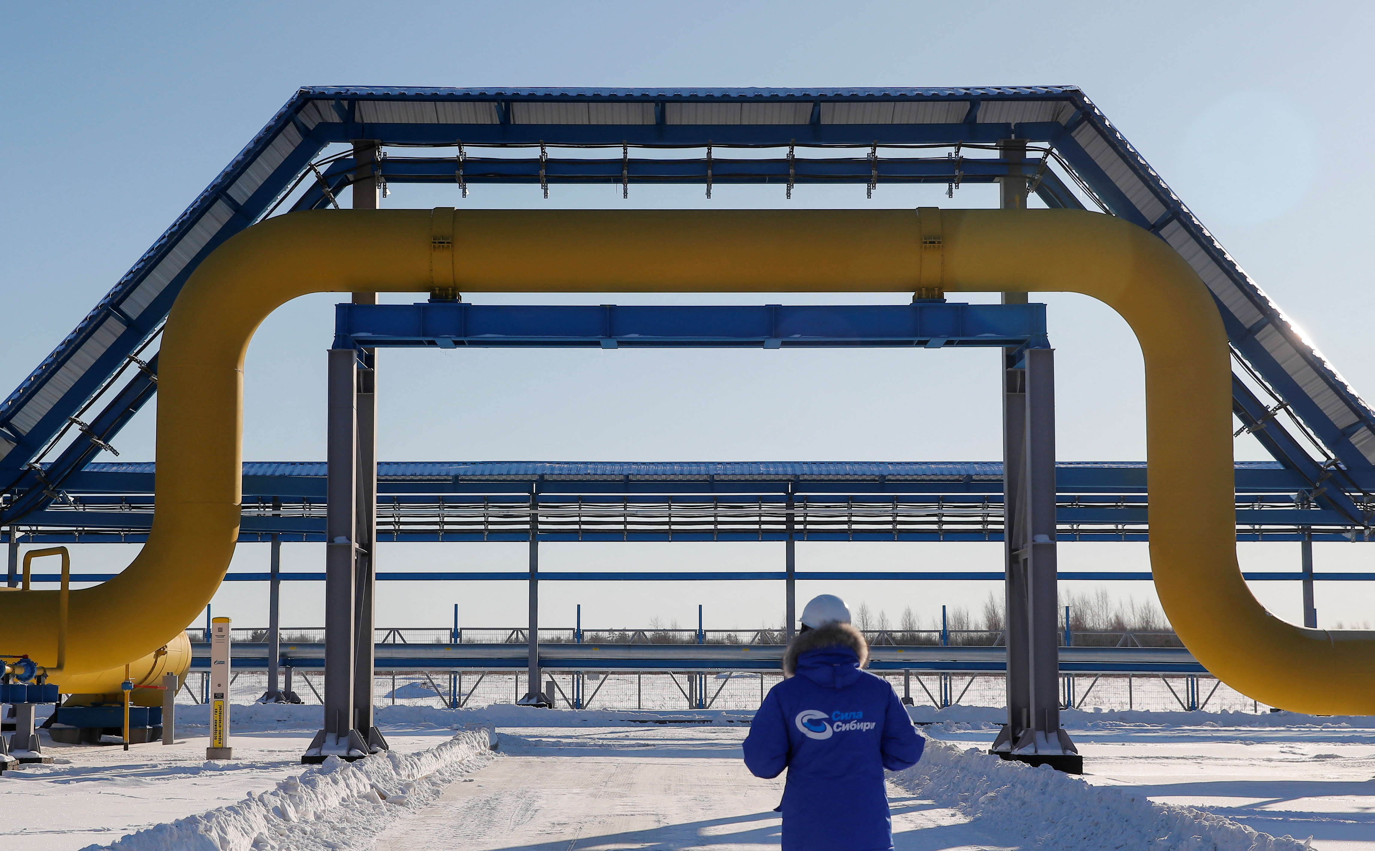 An employee is seen walking past a part of Gazprom's Power Of Siberia gas pipeline at the Atamanskaya compressor station outside the far eastern town of Svobodny, in Russia's Amur region