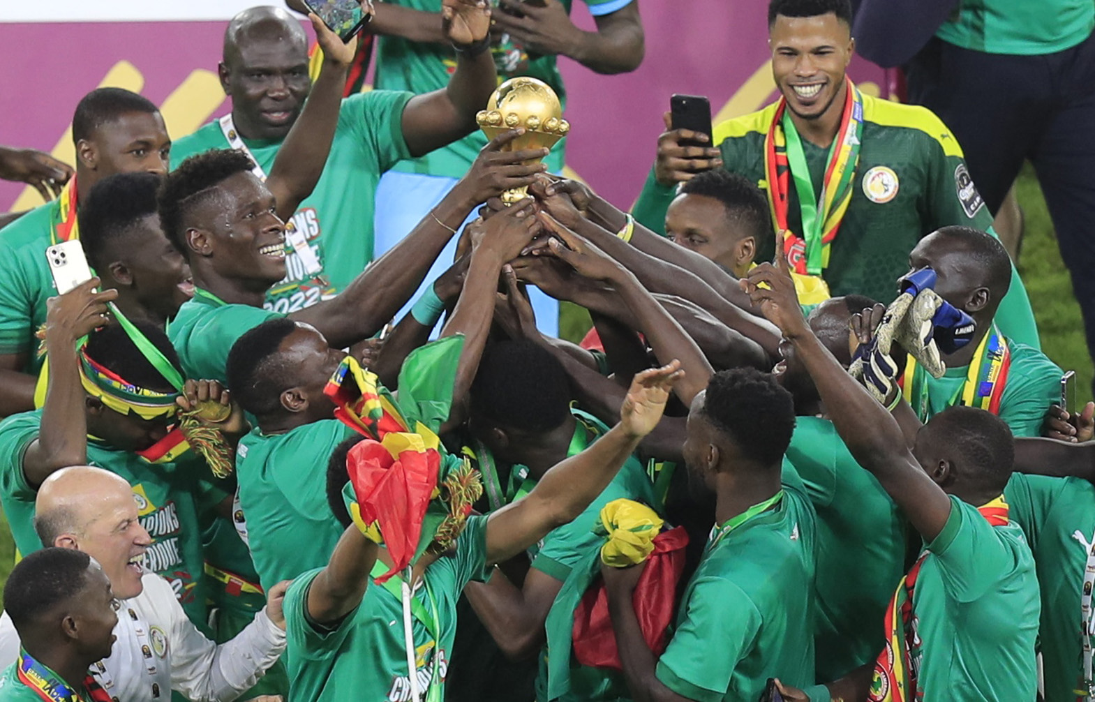 senegal players crowd together to hold aloft the AFCON trophy after their win over Egypt
