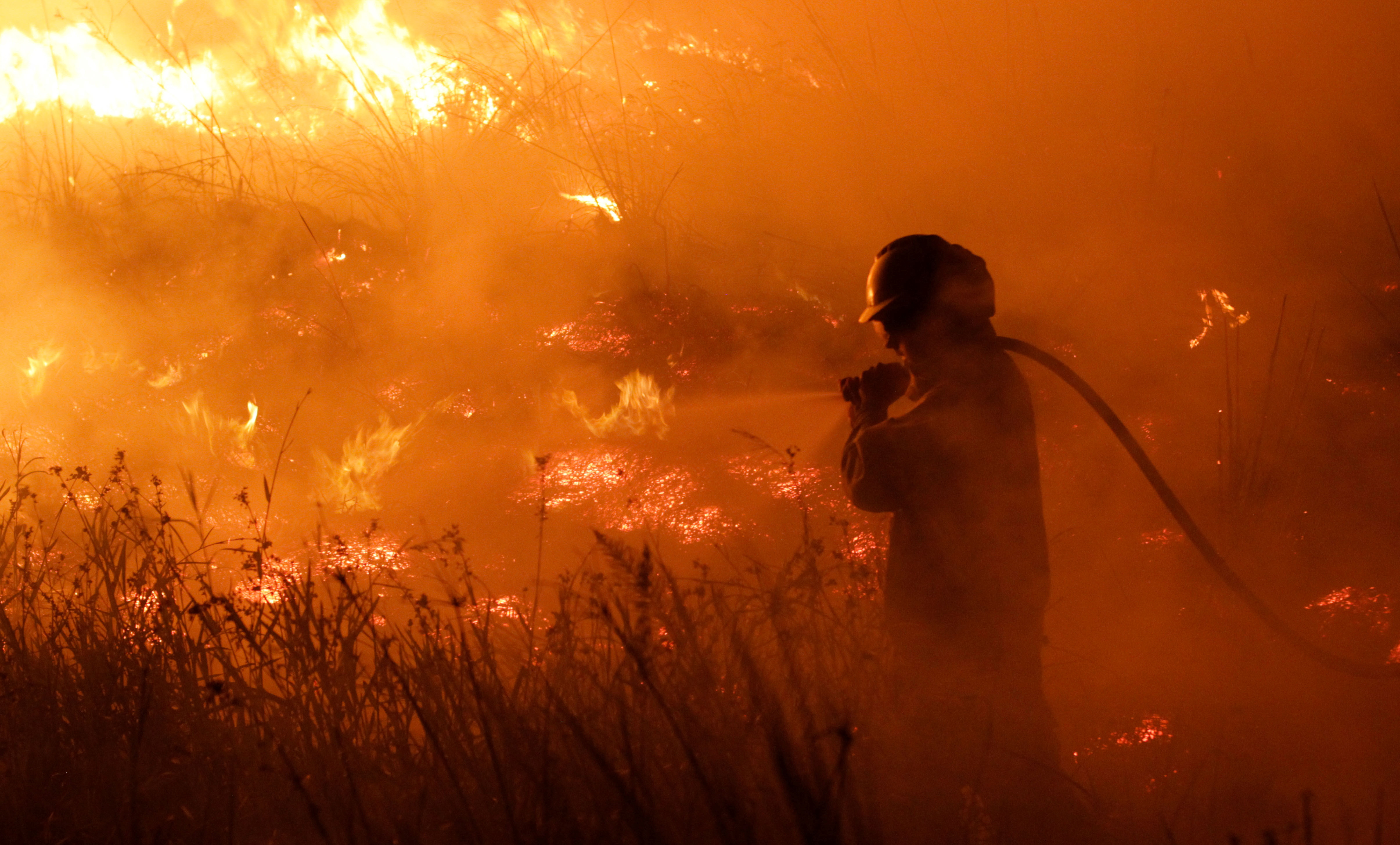 A firefighter battles a wildfire that has spread over more than 500,000 hectares in the norther province of Corrientes, in Portal San Antonio, Argentina February 14, 2022. Picture taken February 14, 2022. REUTERS/Sebastian Toba