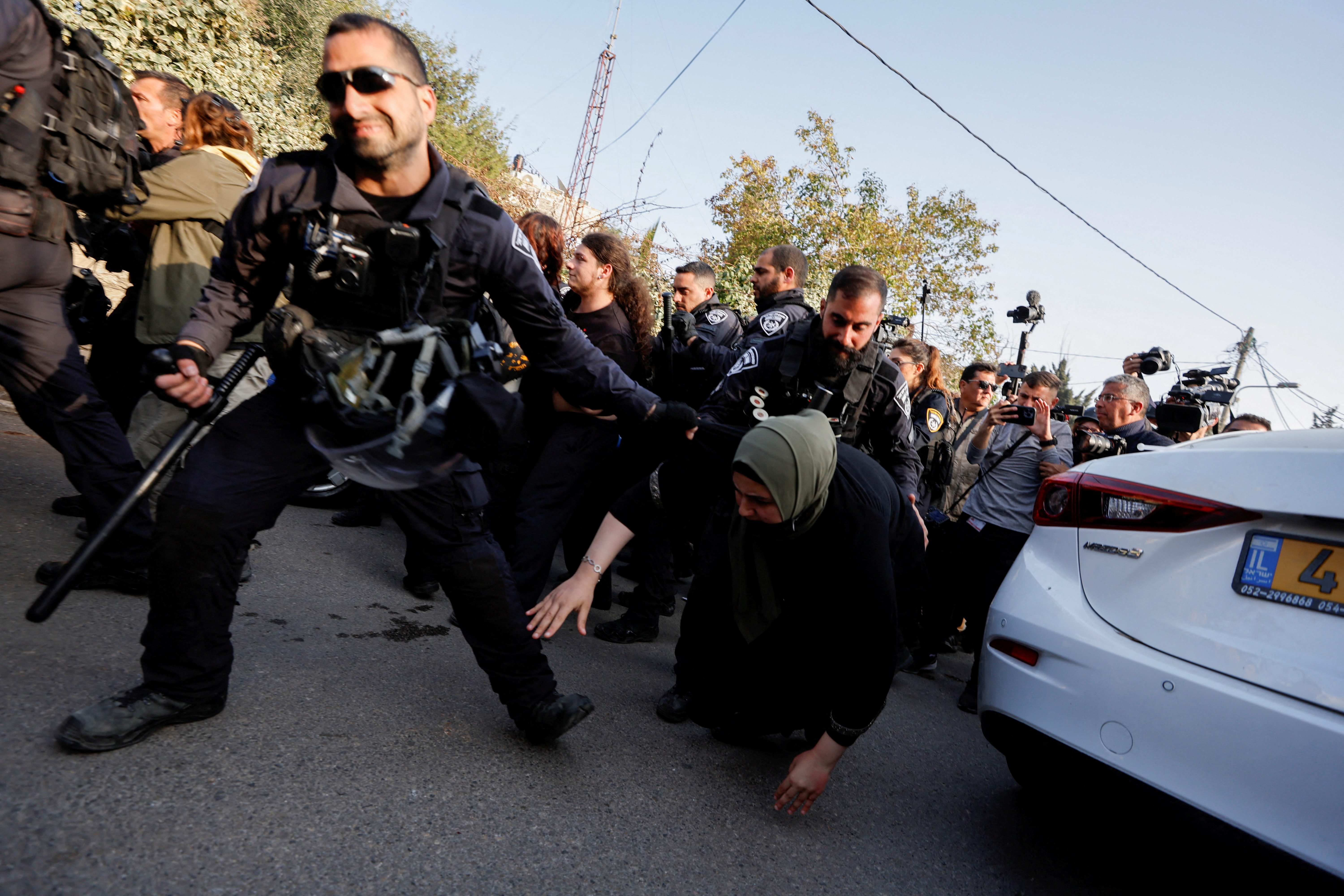 A member of the Israeli security forces pulls a Palestinian woman during a protest in Sheikh Jarrah, occupied East Jerusalem