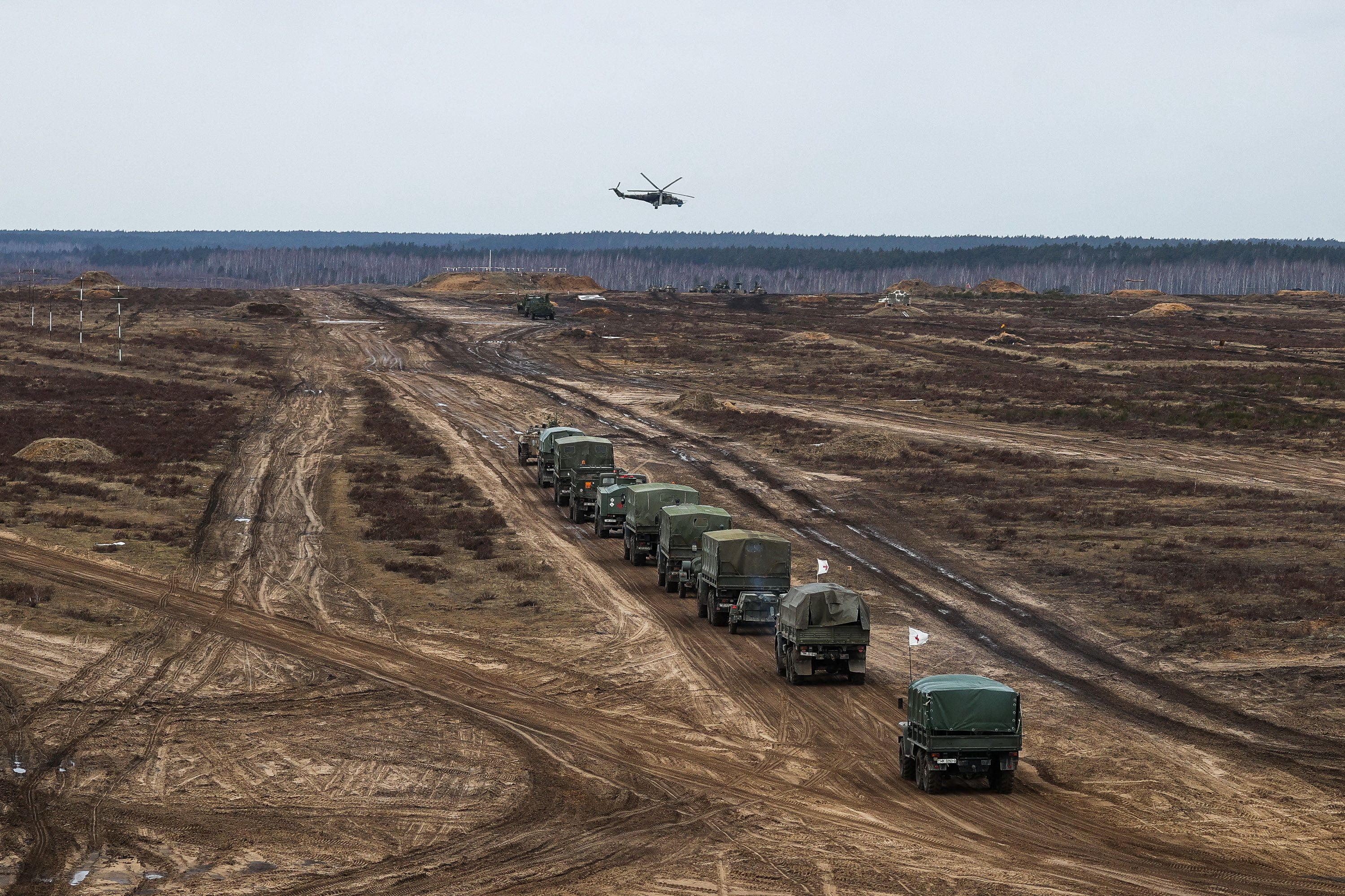 A helicopter flies over troops during the joint military drills of the armed forces of Russia and Belarus at a firing range in the Brest Region, Belarus February 19, 2022