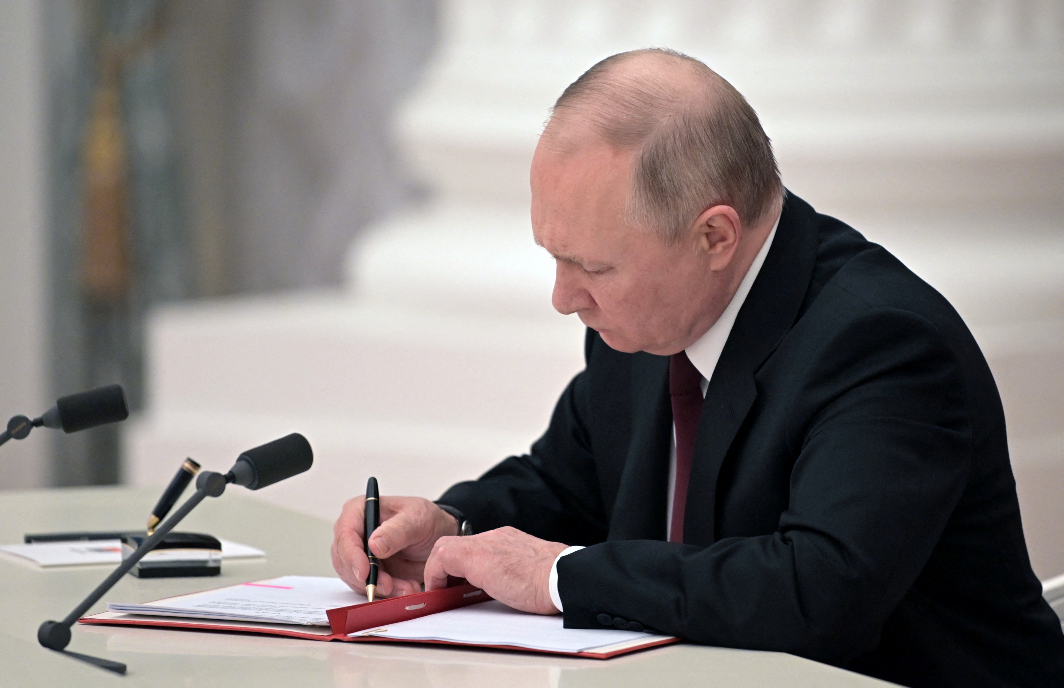 Russian President Vladimir Putin signs documents
