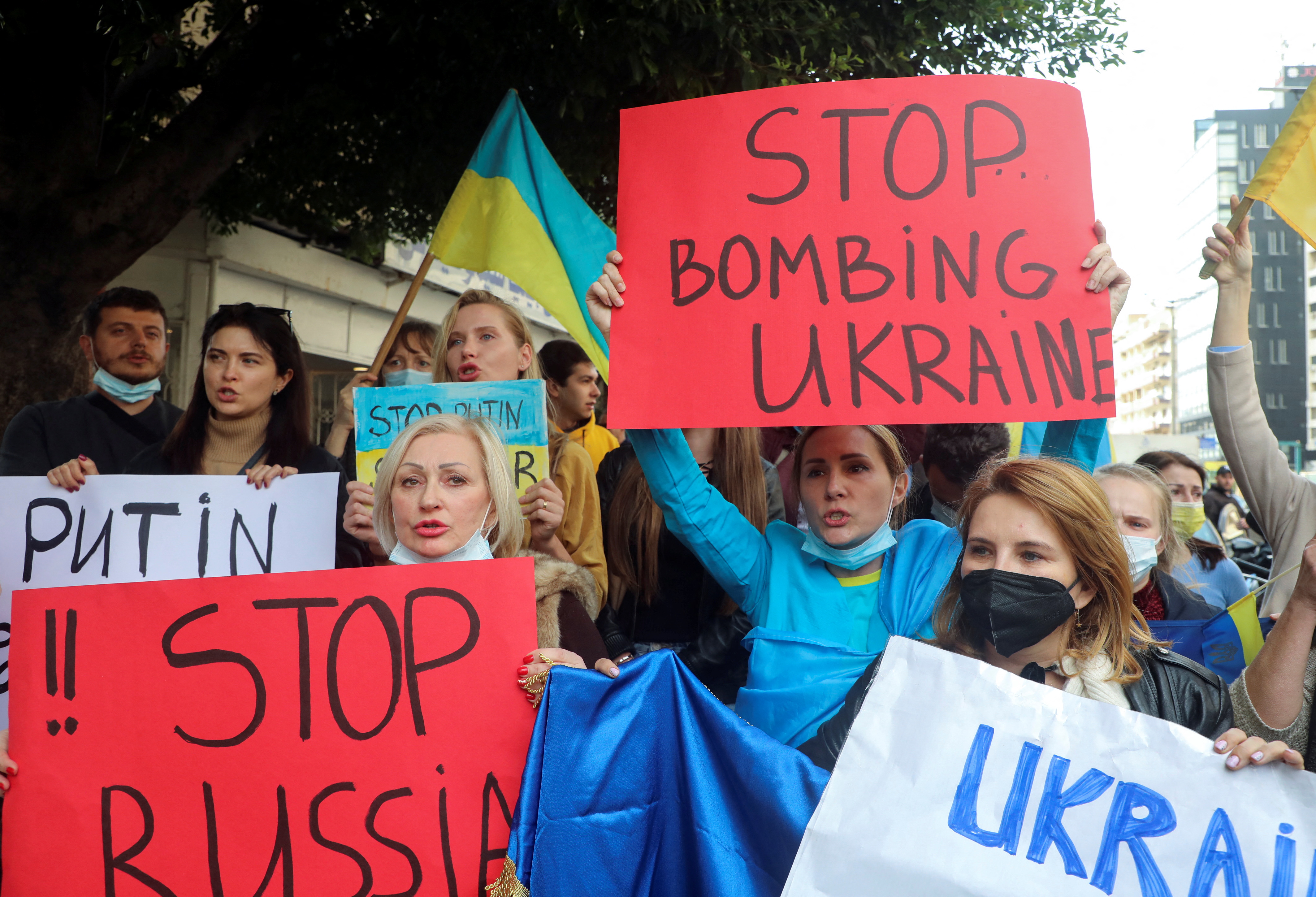 Lebanese and Ukrainians living in Lebanon carry placards