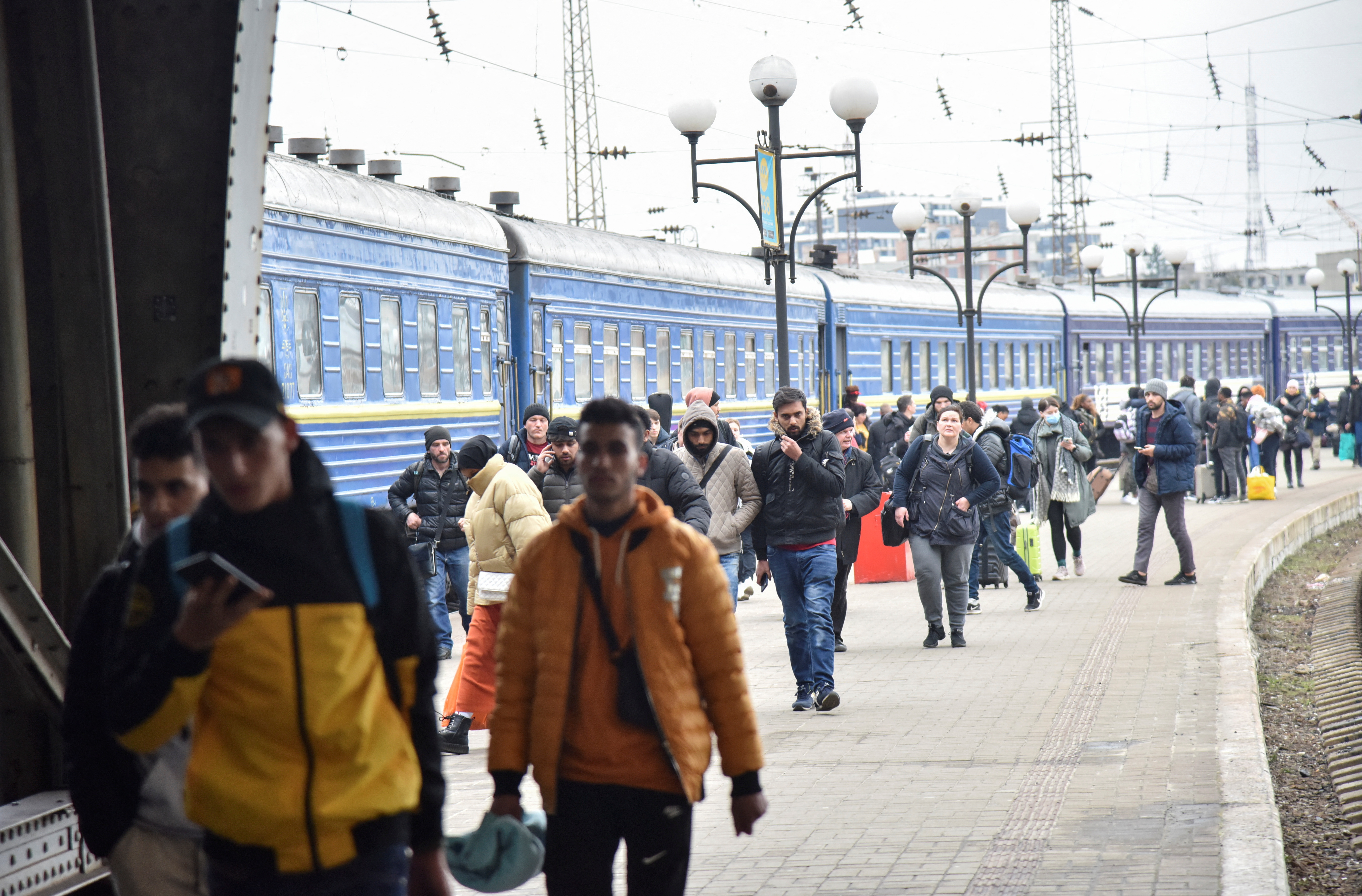 Passengers, including evacuees from the cities of Sumy and Kyiv, walk along the platform of a railway station upon their arrival in Lviv, Ukraine 